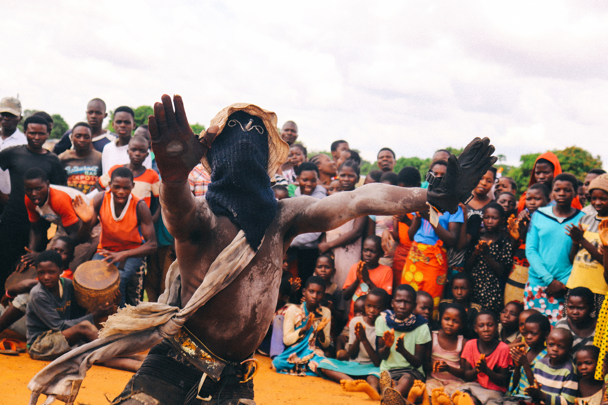 A dancer in traditional attire performs in front of a captivated crowd, showcasing vibrant cultural celebration.