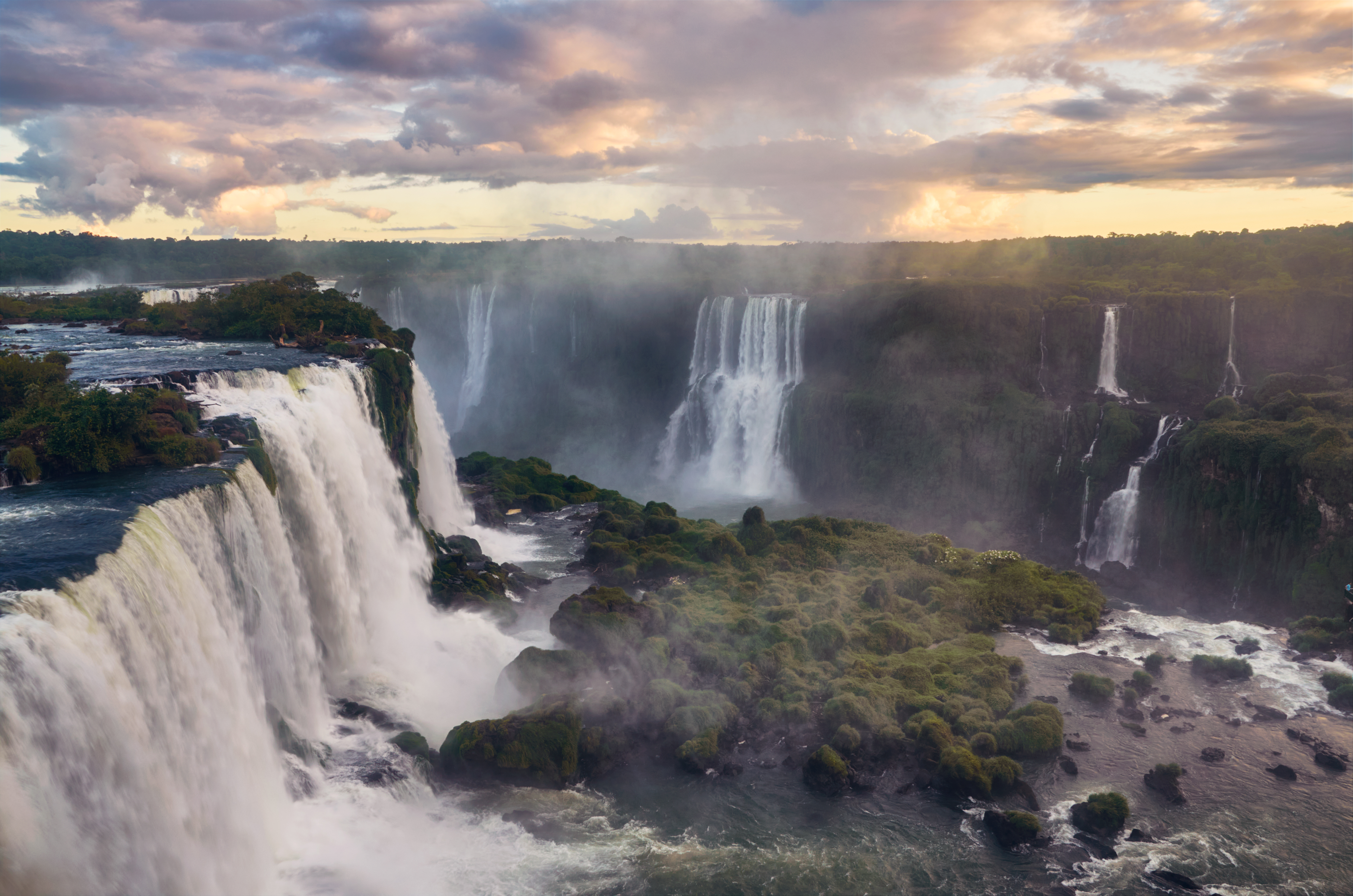 Breathtaking view of the Iguazu Falls gleaming under the cloudy sky in South America