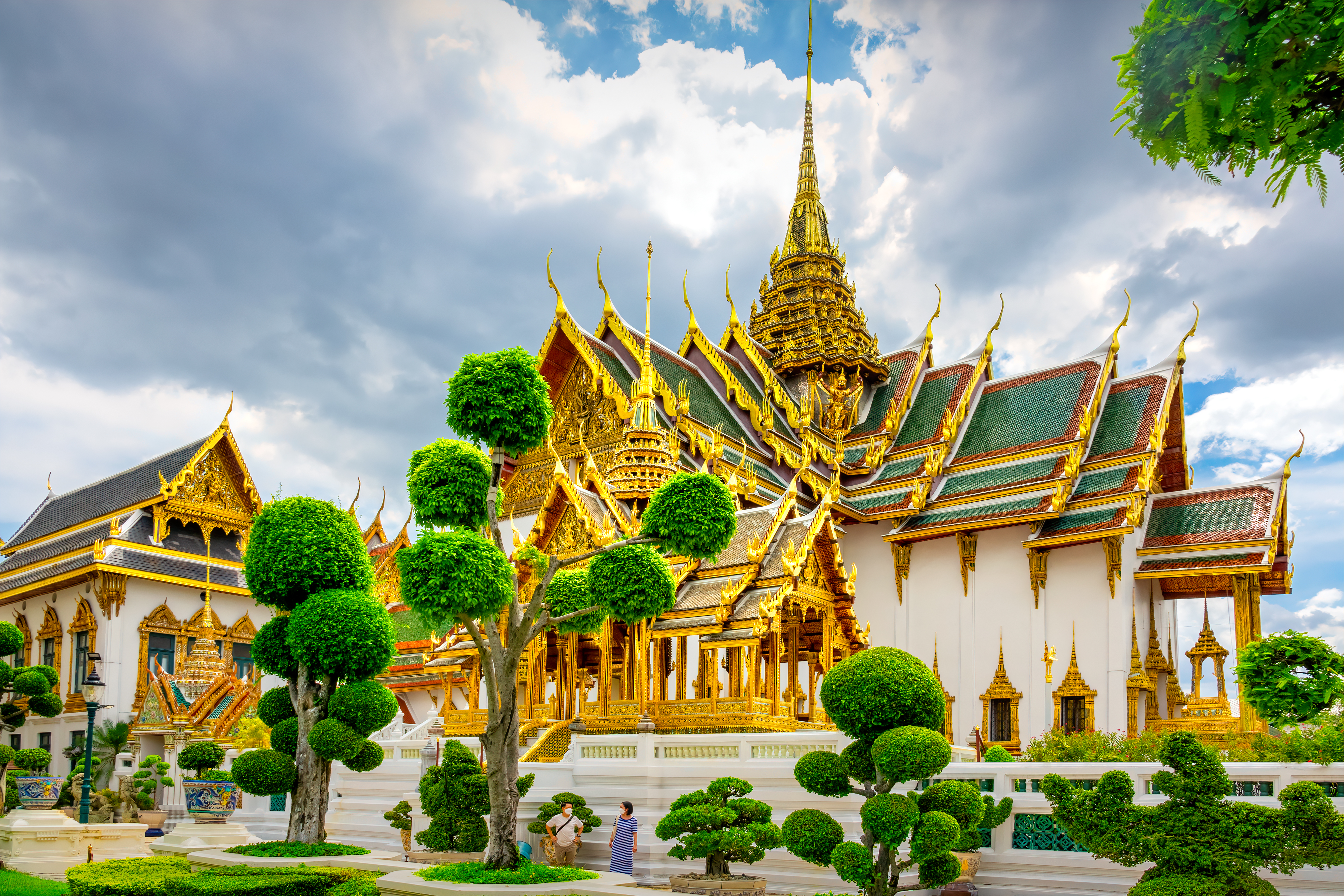 People stand at Phra Thinang Dusit Maha Prasat throne hall building, part of the Grand Palace in Bangkok,