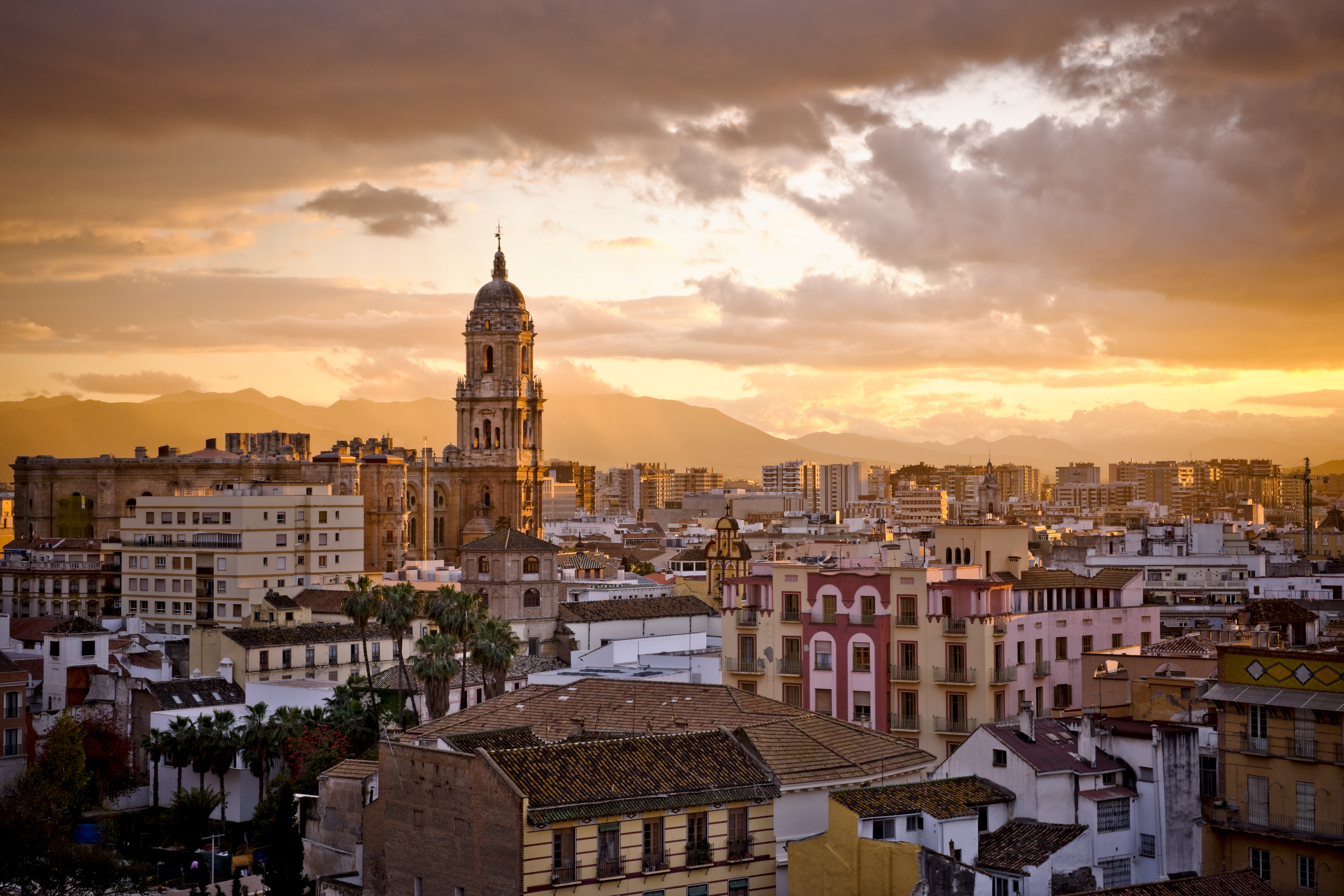 Sunset over city skyline and distant mountains