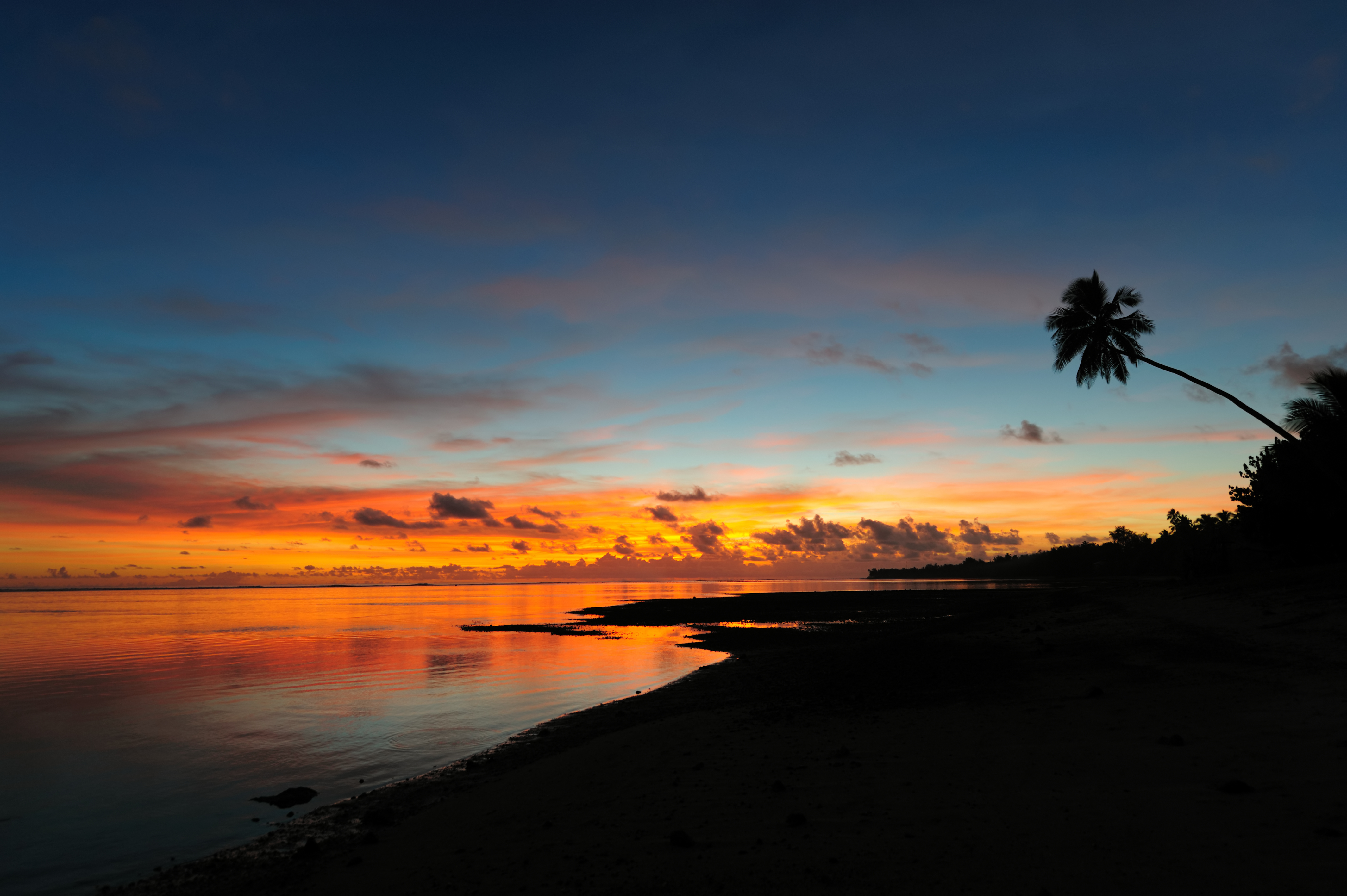 The beautiful tropical beach of Rarotonga / the Cook Islands at sunset.