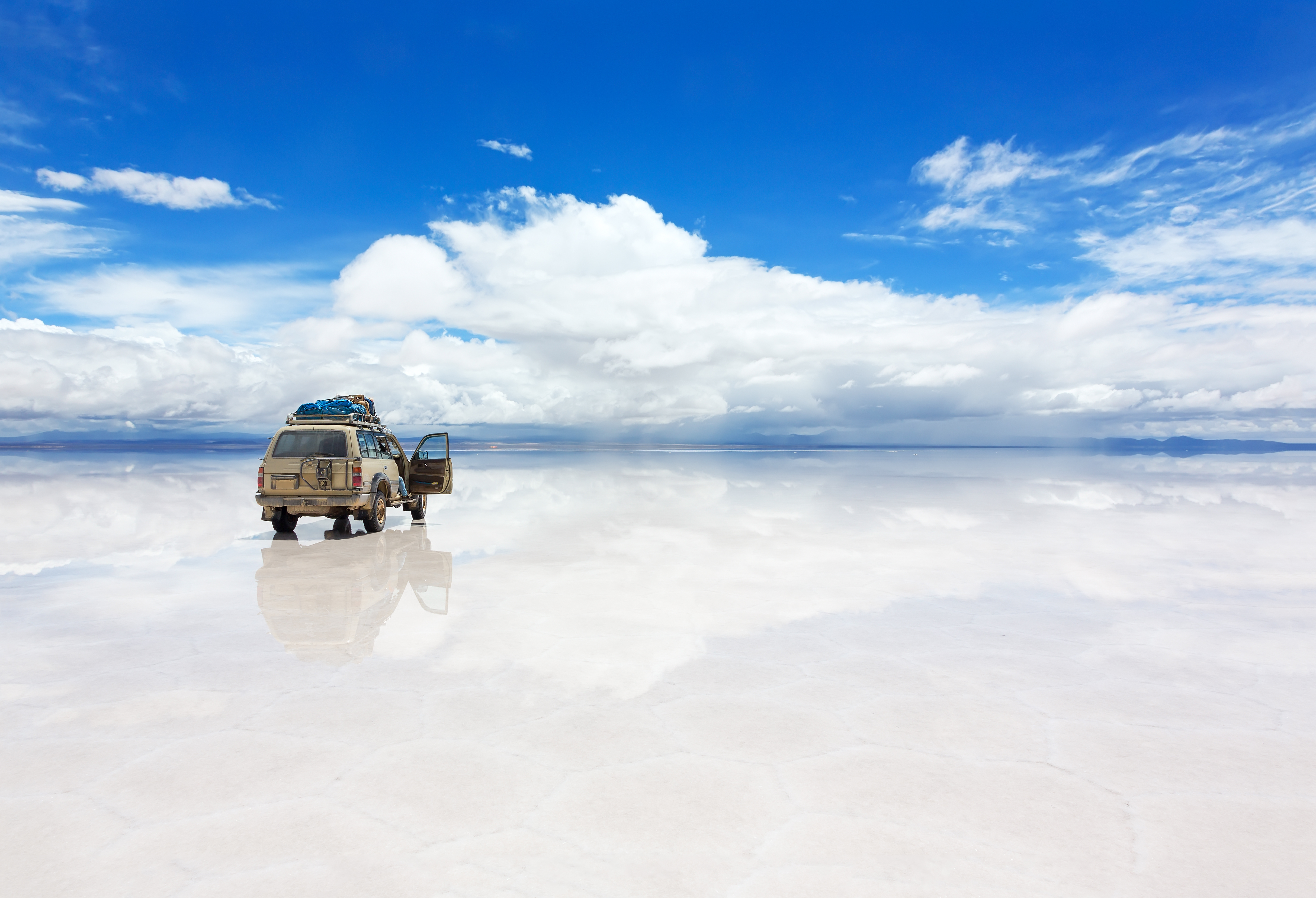 The world's largest salt flat, Salar de Uyuni in Bolivia, with Jeep vehicle driving over