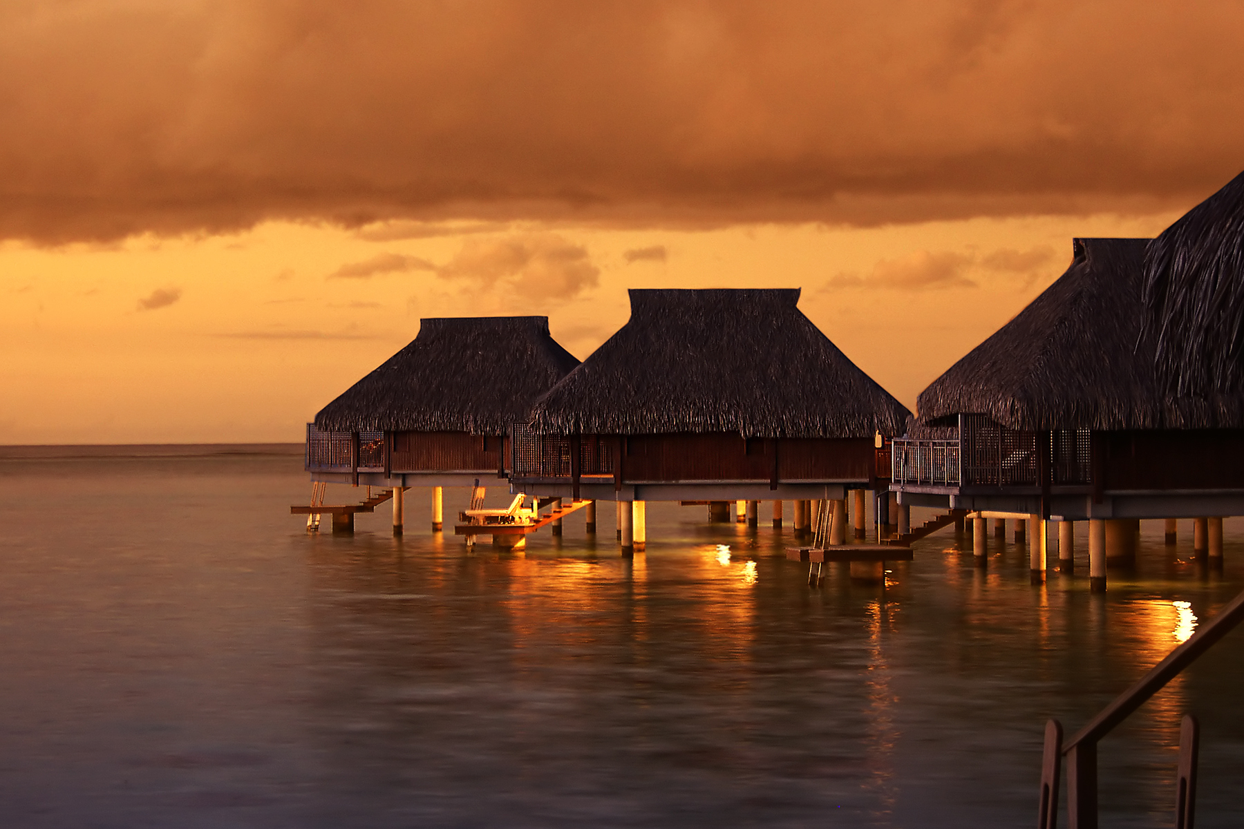 Tropical Tahiti bungalows at sunset
