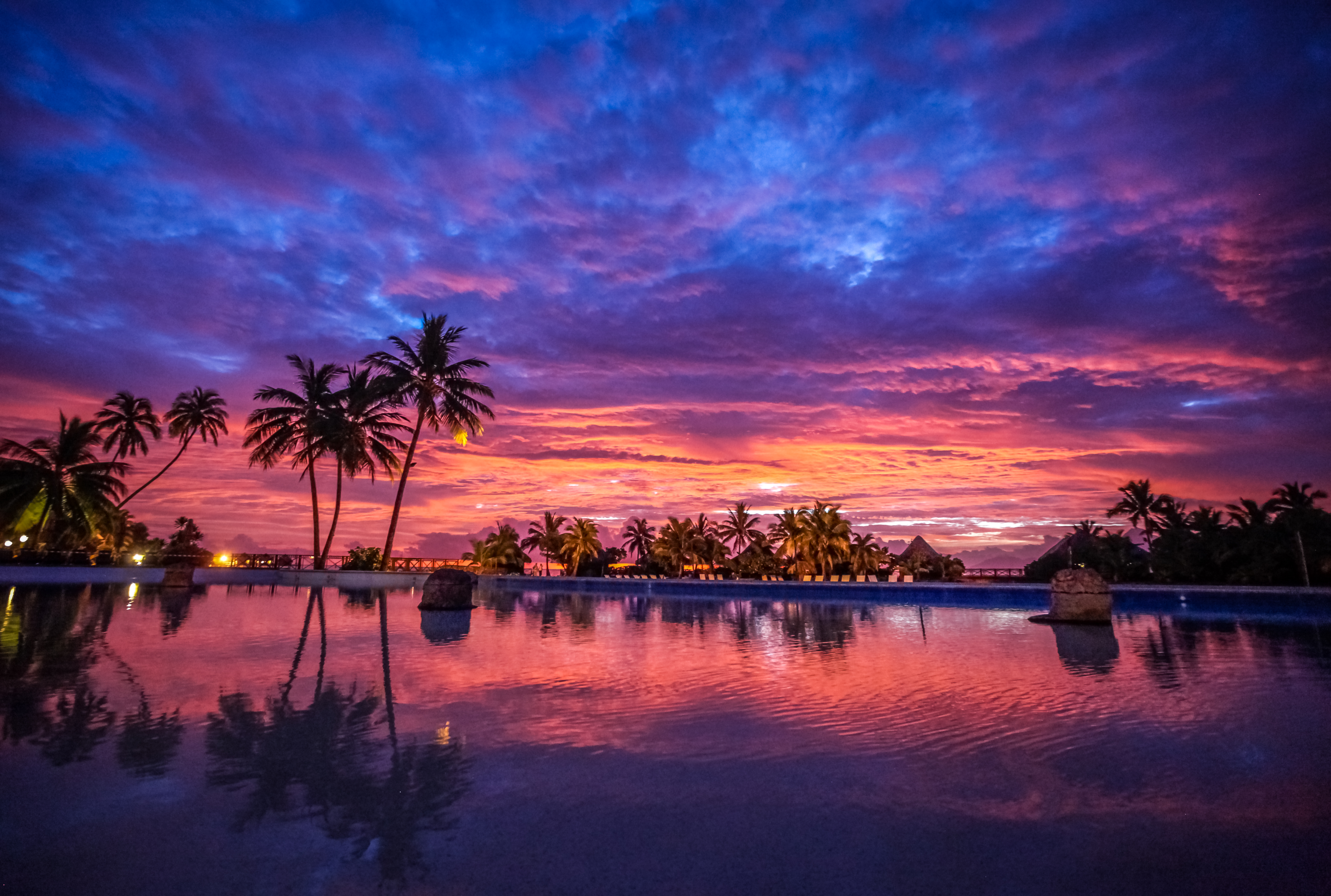 Vibrant and colourful sunset over bungalows and palm trees