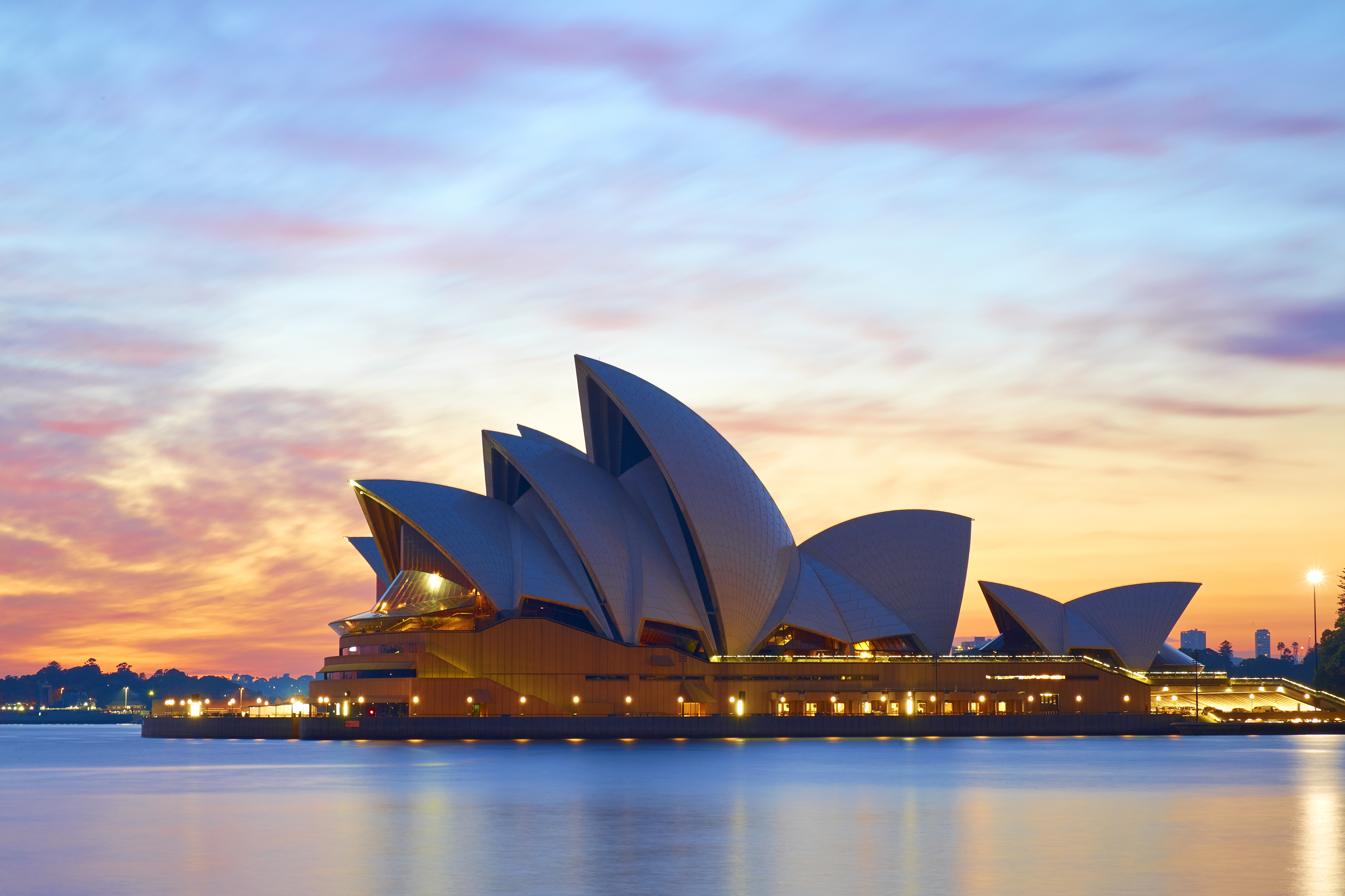 Early morning in Sydney, and the iconic shape of the city's Opera House stands out against a glorious pre-dawn sky