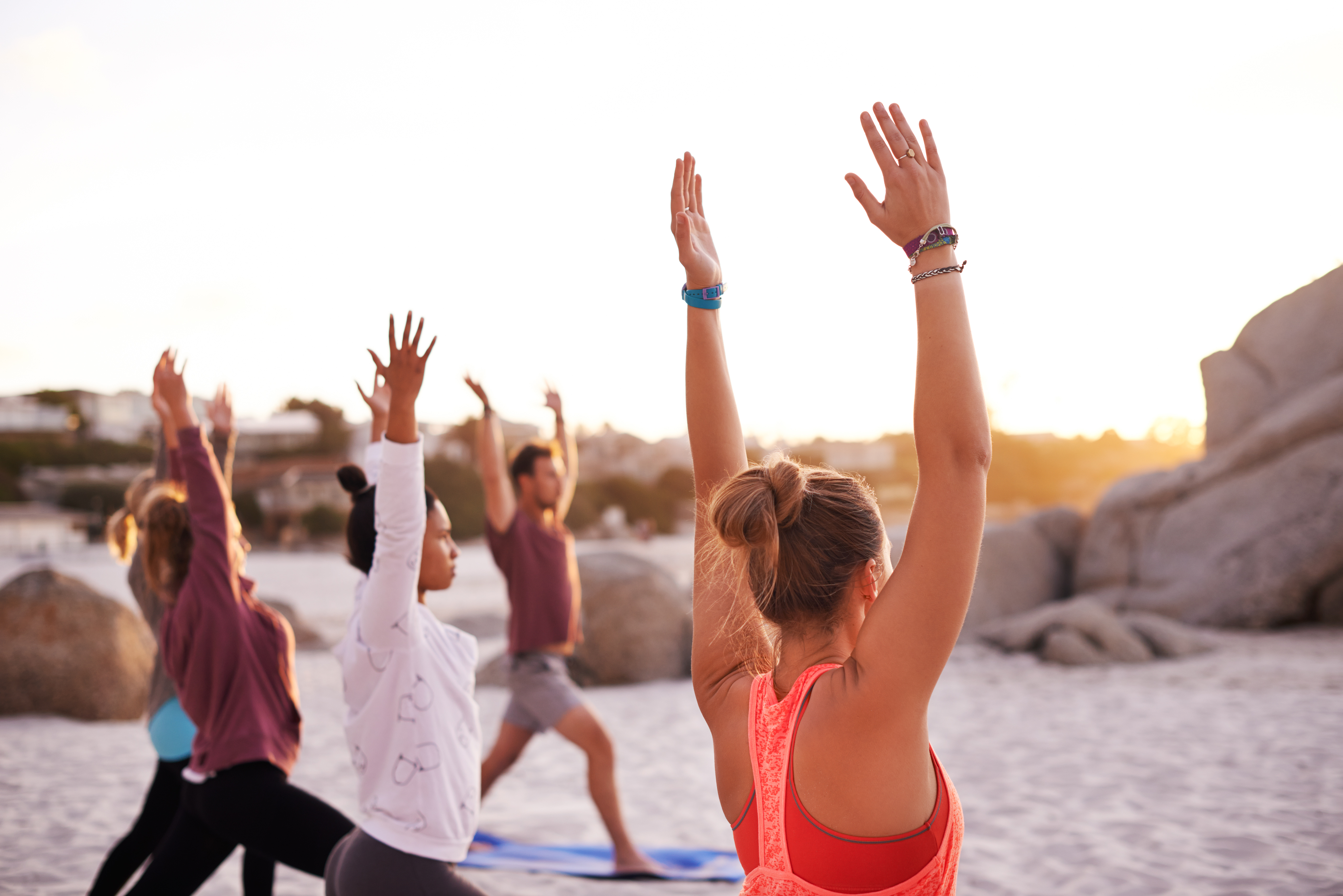 Shot of a group of people having a yoga session on the beach