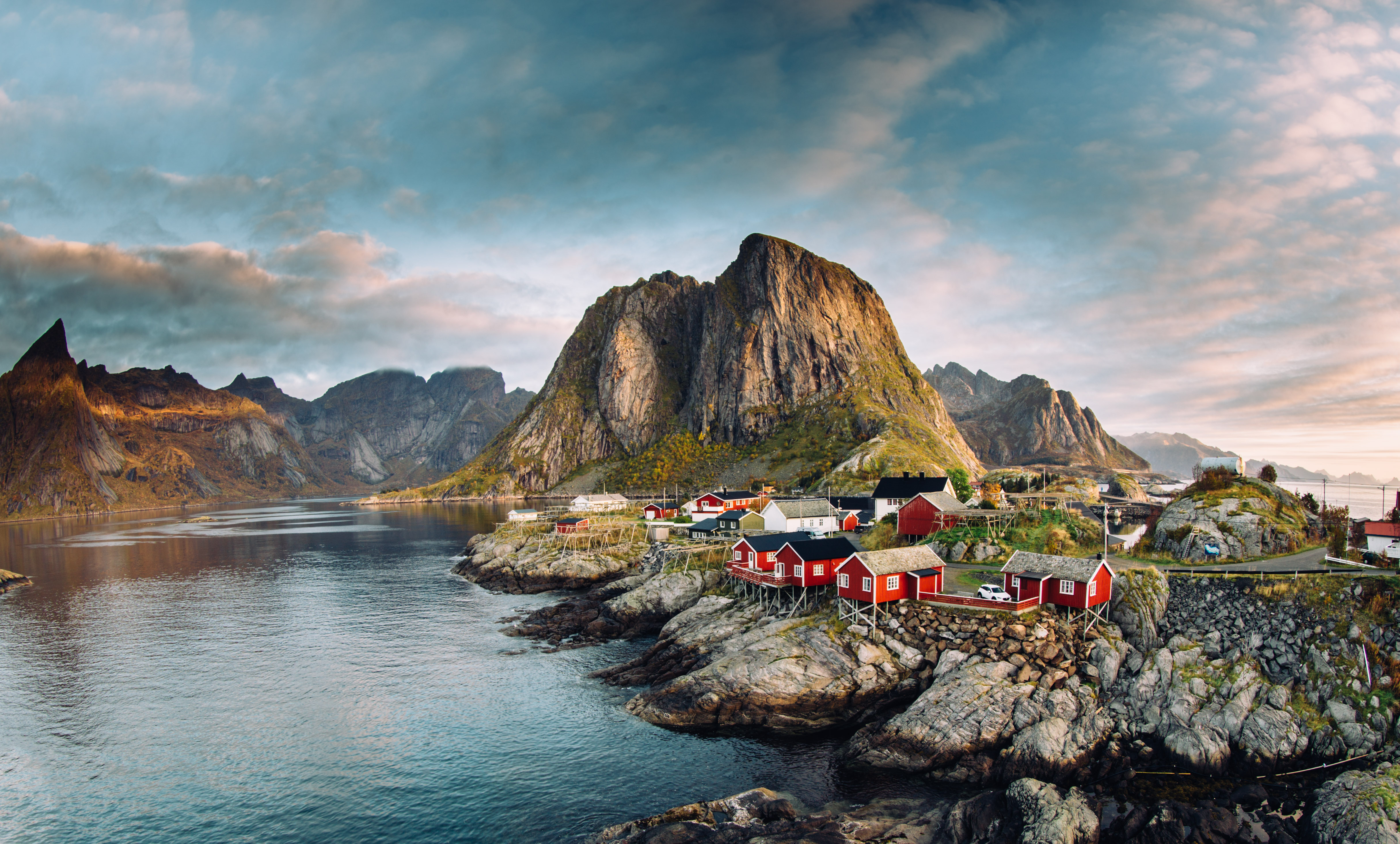 Dramatic sunset clouds moving over steep mountain peaks of Norwegian fishing village in the Lofoten Islands in Norway. 