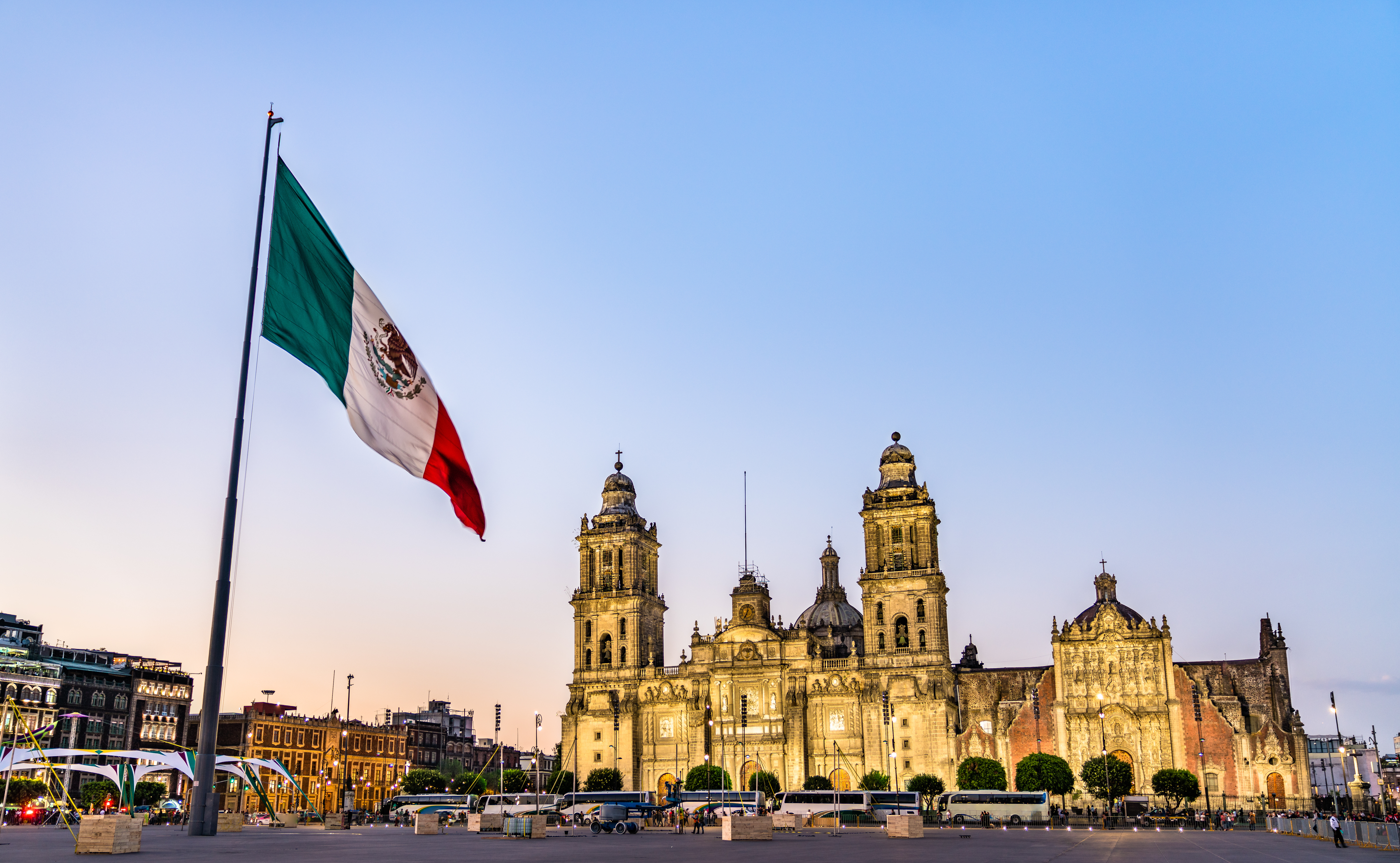 Mexican flag on a pole in front of the Metropolitan Cathedral in Mexico City