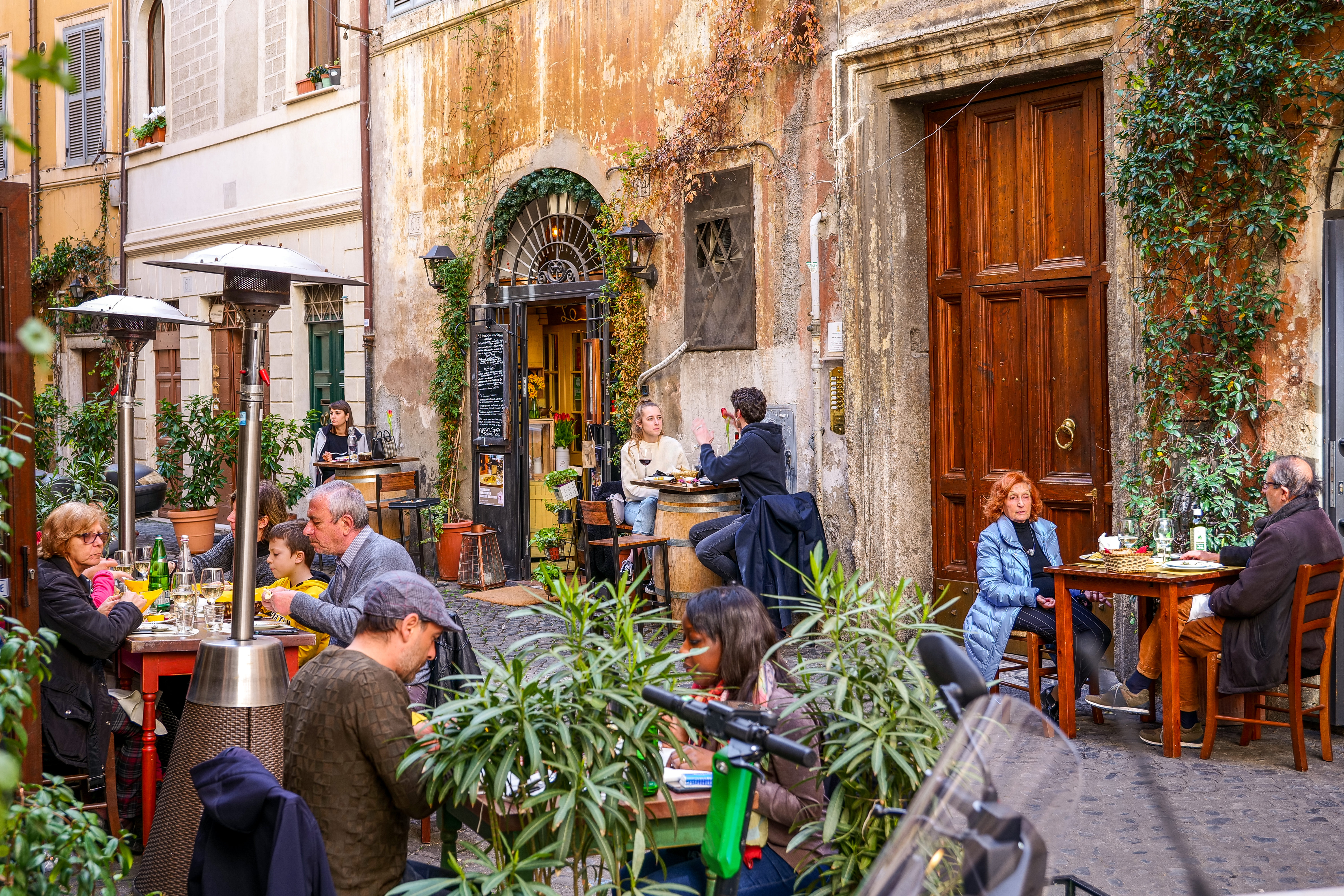 Some customers enjoy Italian life and food in a delightful restaurant.