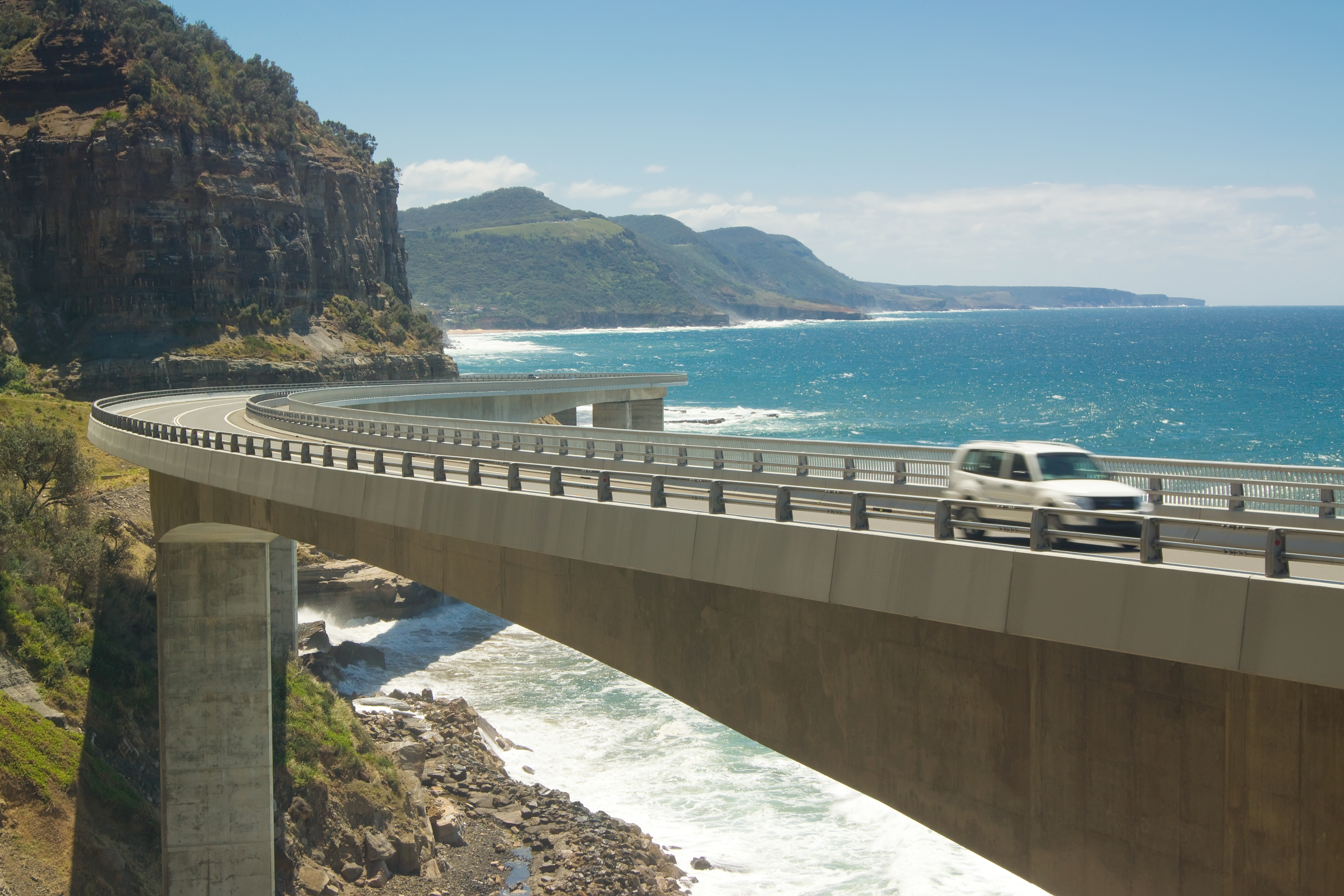 A car goes across the Sea Cliff Bridge