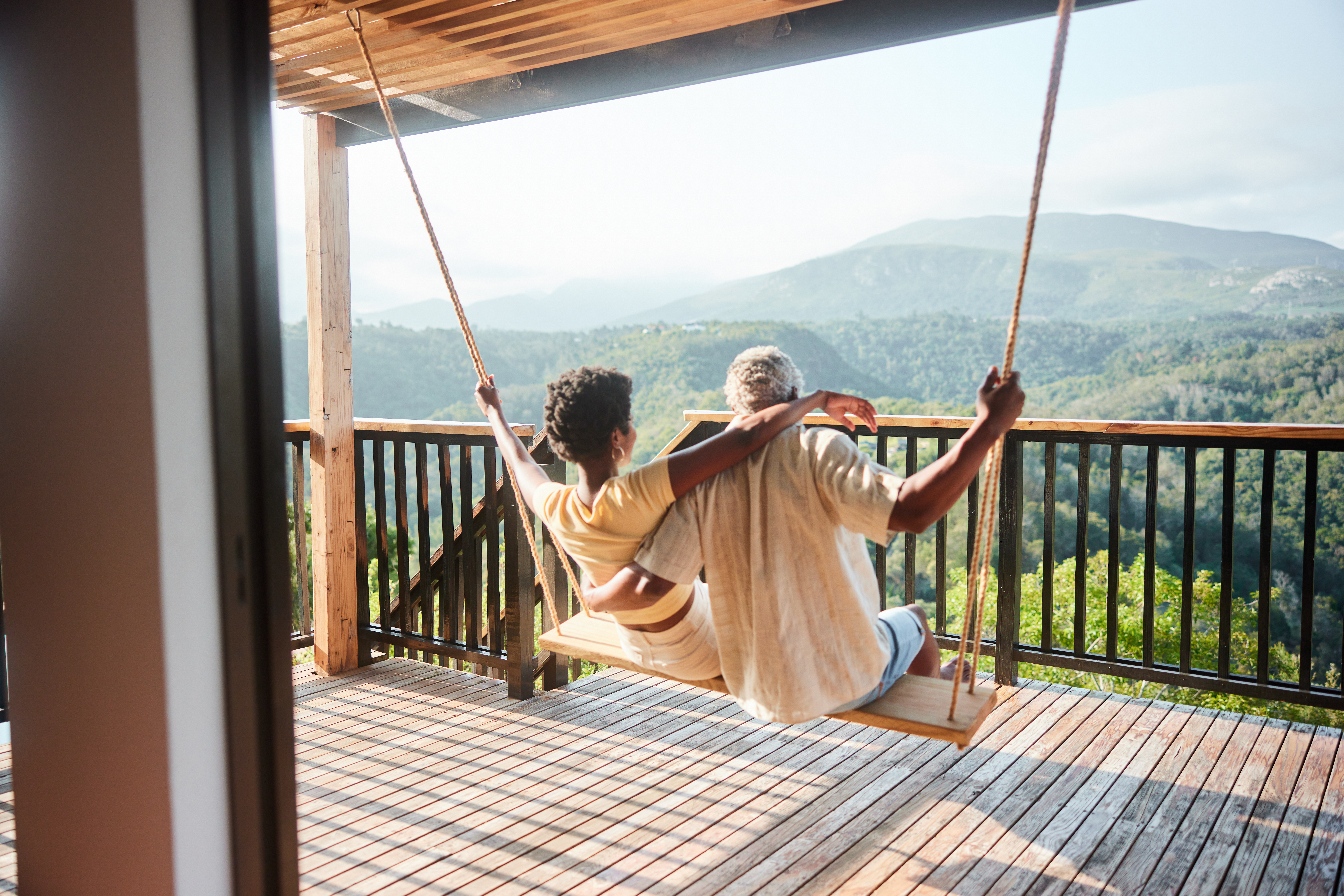 A couple on a swing in their hotel overlooking South Africa scenery