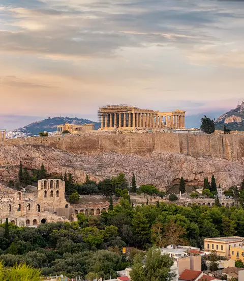 View to the Acropolis of Athens on top of the old town Plaka during a cloudy summer sunset, Greece