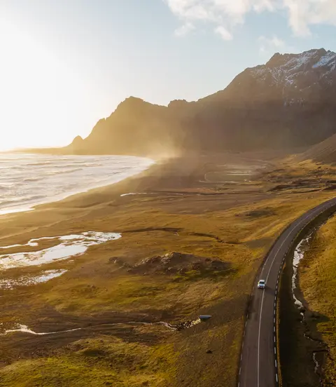 Aerial view of a car driving on scenic road in Iceland