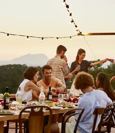 Friends enjoying at patio during social gathering at sunset in Spain