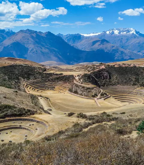 Ancient Inca circular terraces with Andes mountains in the background