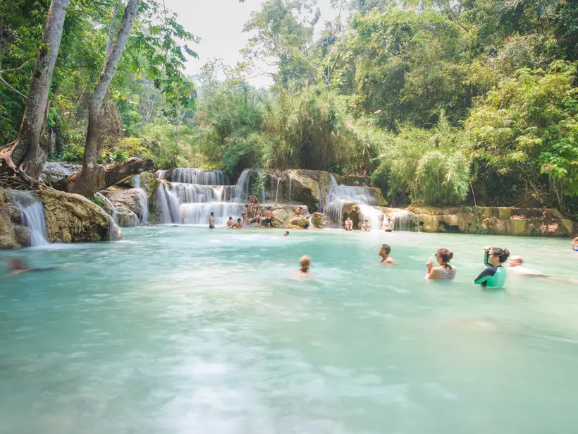 Tourists swimming by the waterfall
