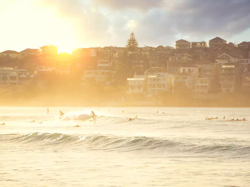 People relaxing at bondi beach at sunset
