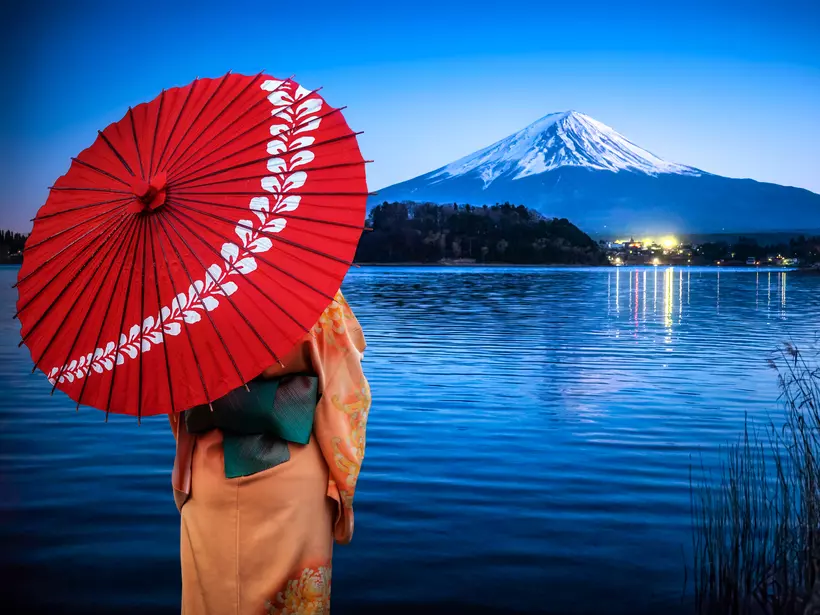 Lake Kawaguchi, Yamanashi, Japan Woman enjoying the view of Mount fuji at night reflected on Lake Kawaguchi