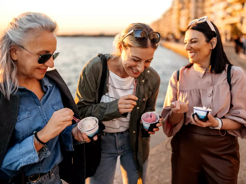 Friends share ice cream on the beach