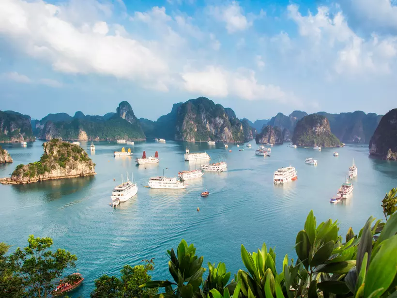 Halong Bay Vietnam panorama at sunset with anchored tourist ships