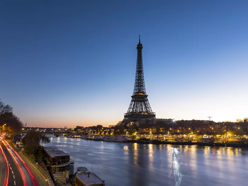 An early morning sunrise takes place behind the majestic Eiffel Tower in the city of Paris in France
