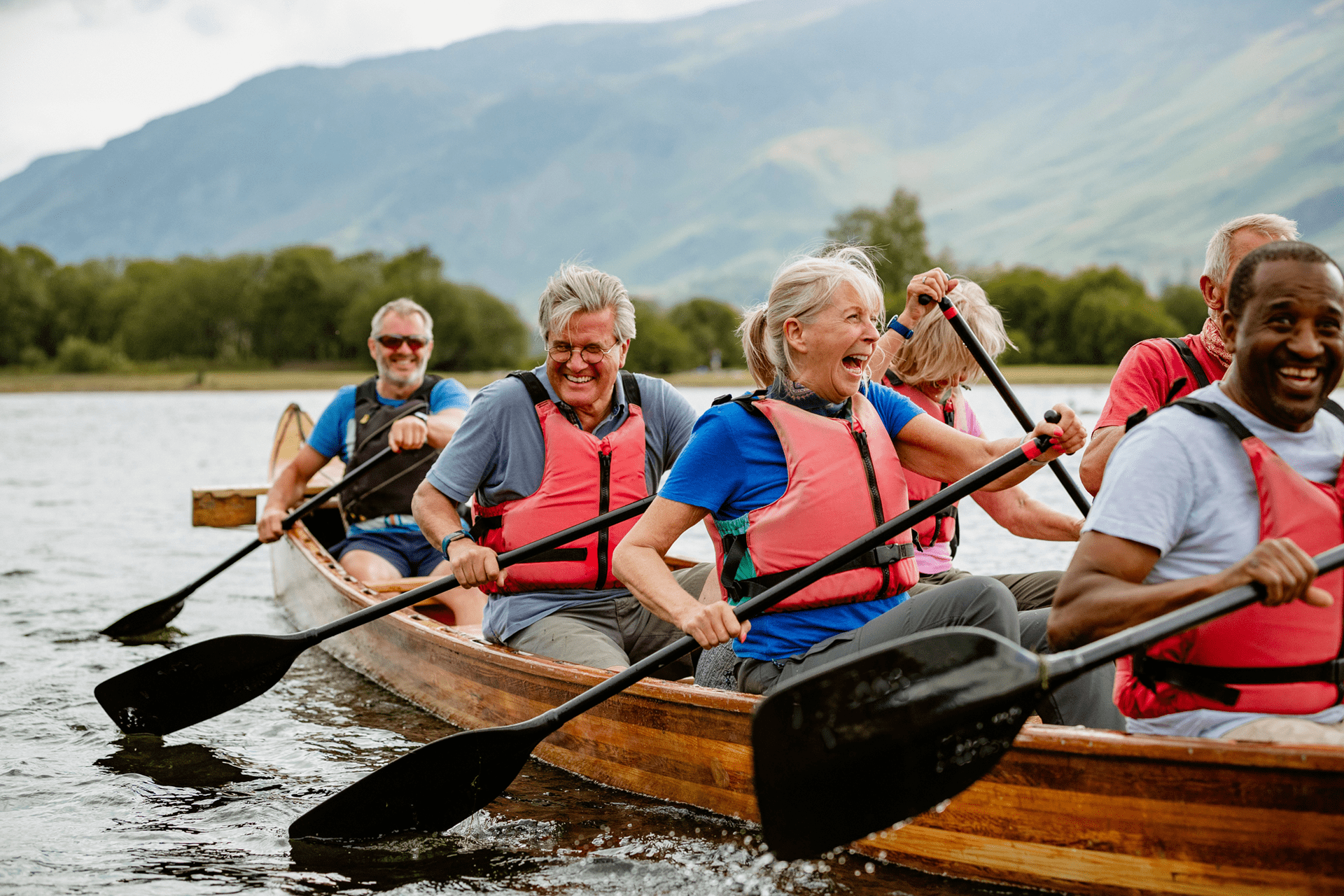 River Derwent, Derbyshire A senior group of tourists enjoying rowing on the River Derwent