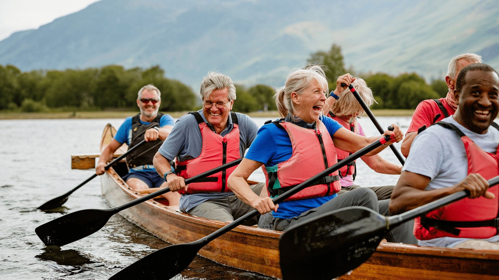 A senior group of tourists enjoying rowing on the River Derwent
