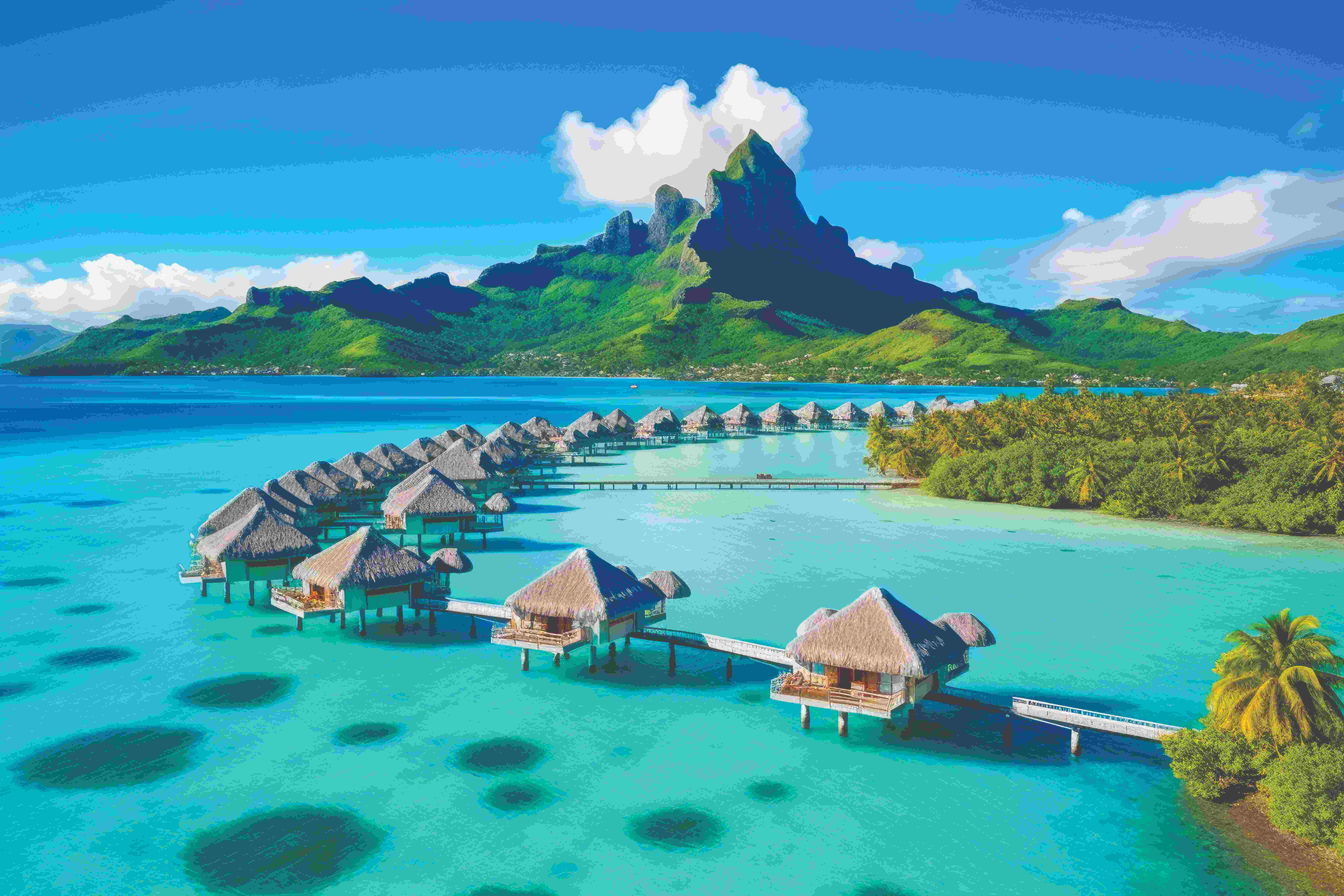 Overwater bungalows with mountain in background