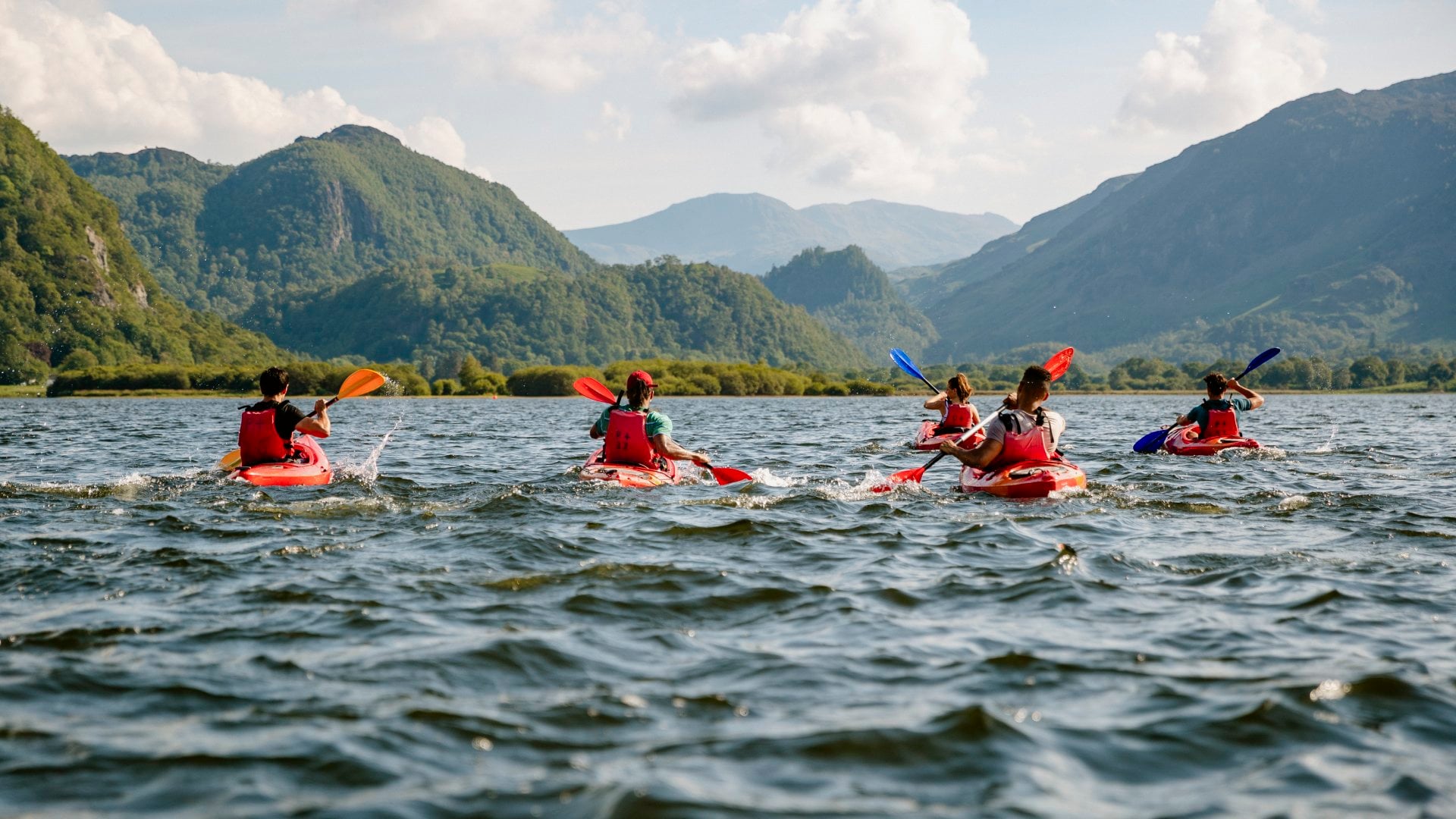 Group learning to kayak across water on Derwent Water in The Lakes District in Cumbria