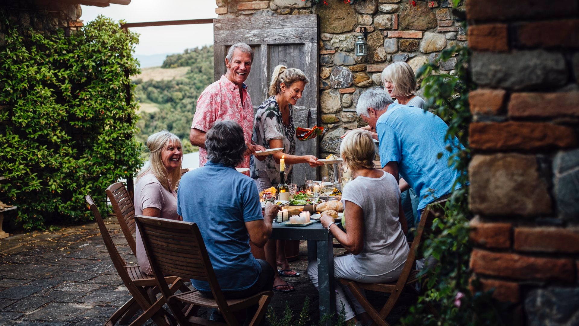 A group of people eat dinner at an outdoor dining table in Italy.