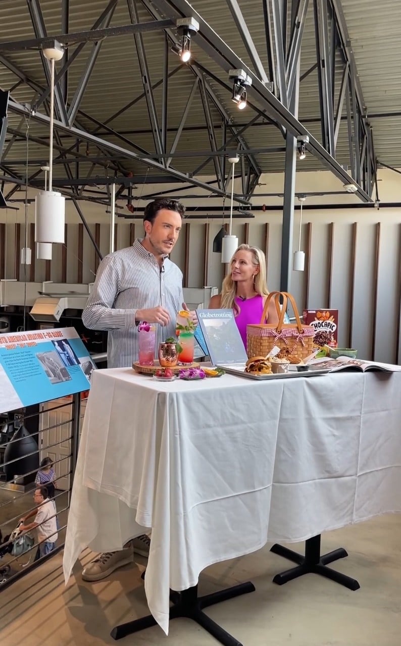 Mitchell Fawcette, Editor-in-Chief of Globetrotting Magazine, and Amber Pfister of NBC's California Live smiling before their local news segment.