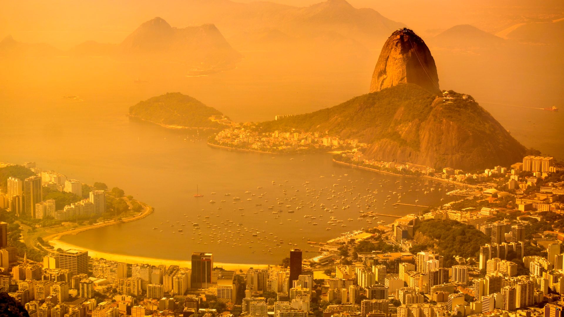 Aerial view of Rio de Janeiro with sugarloaf mountain and Guanabara Bay at background.