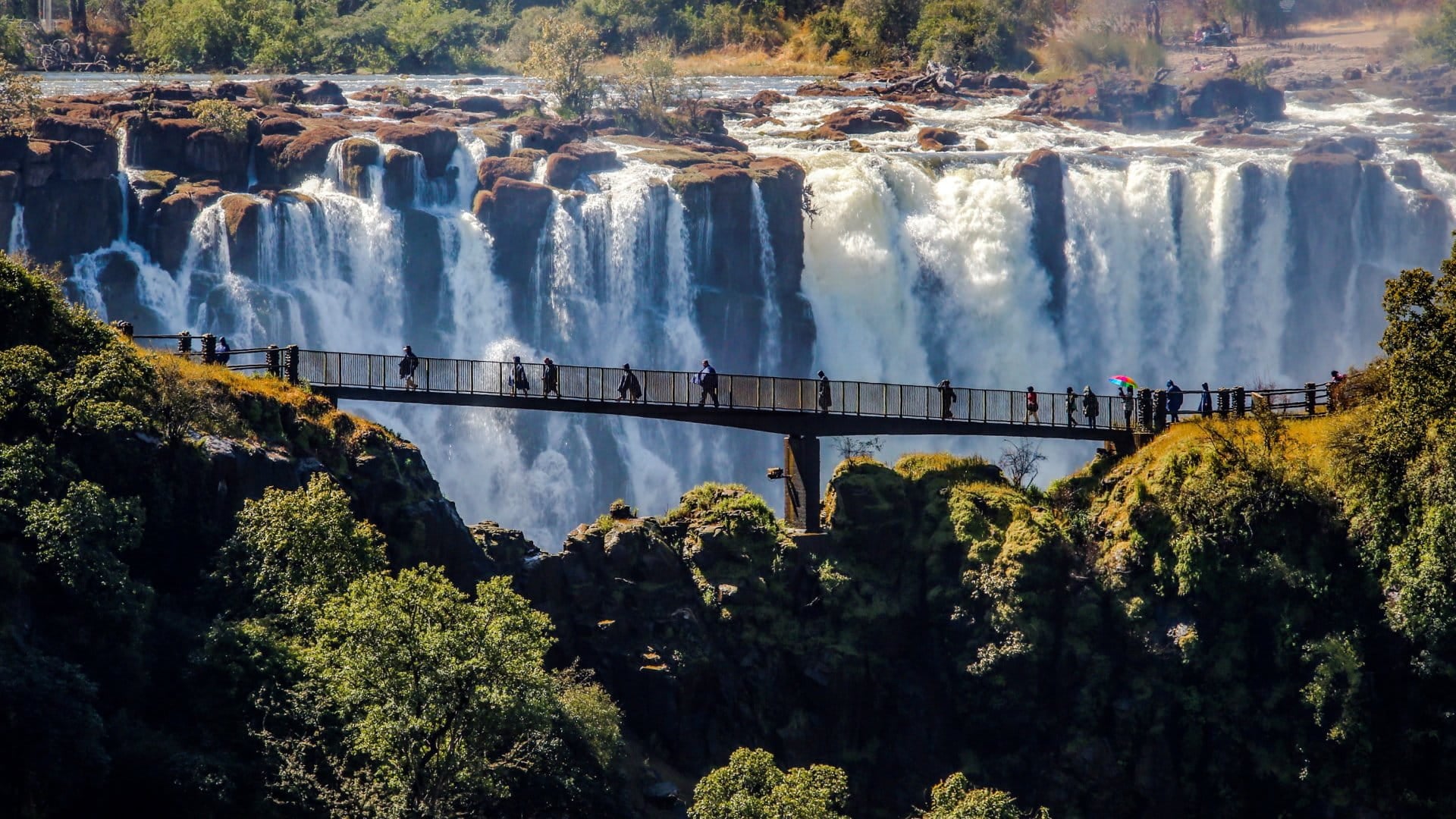 Aerial view of people walking across Victoria Falls, Zimbabwe.