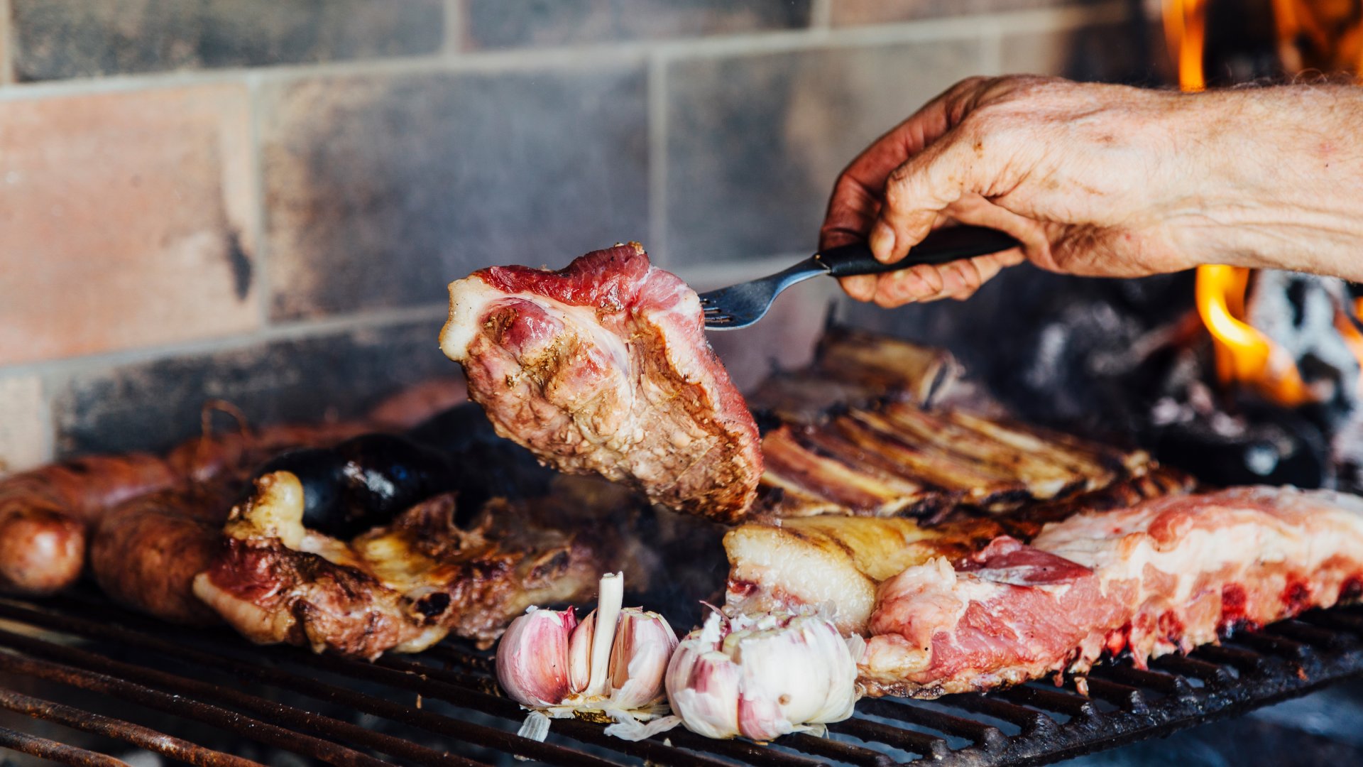 Argentinian meat roasting on the grill. Man making a traditional barbecue called Asado in Argentina.