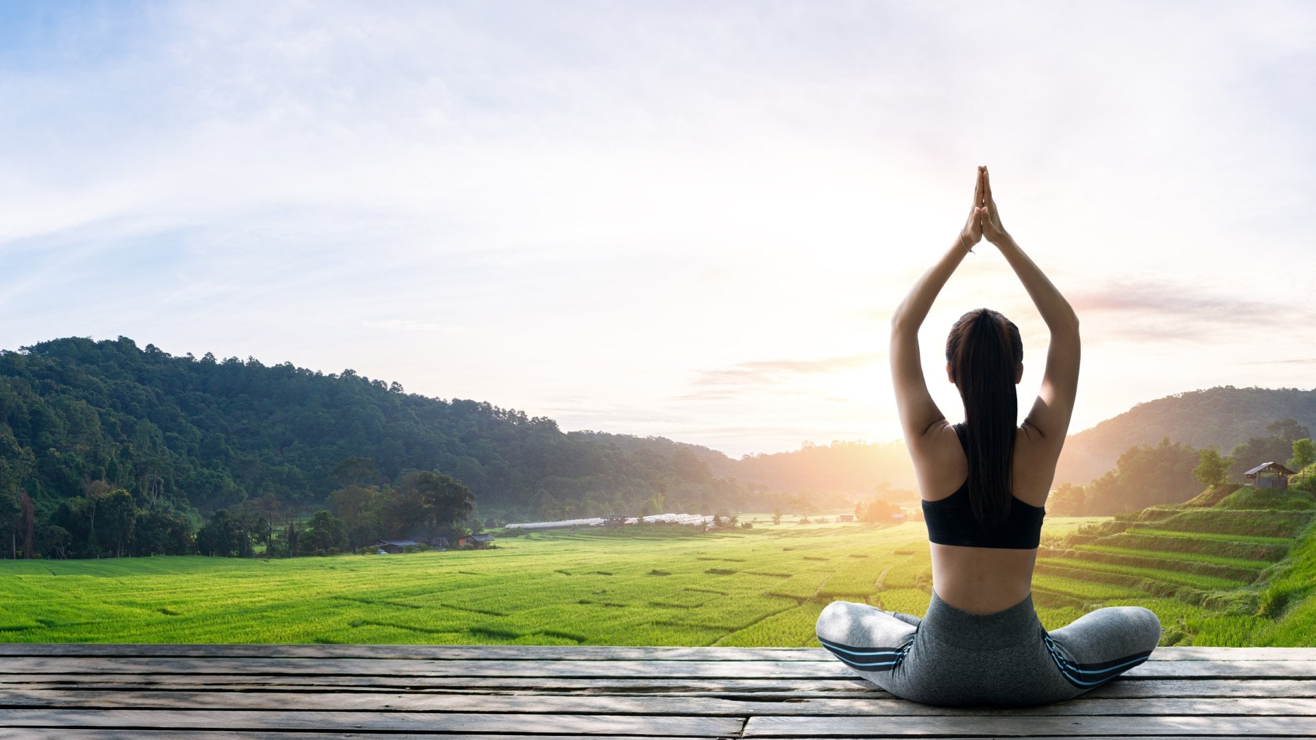 Asian woman doing yoga on the wooden balcony