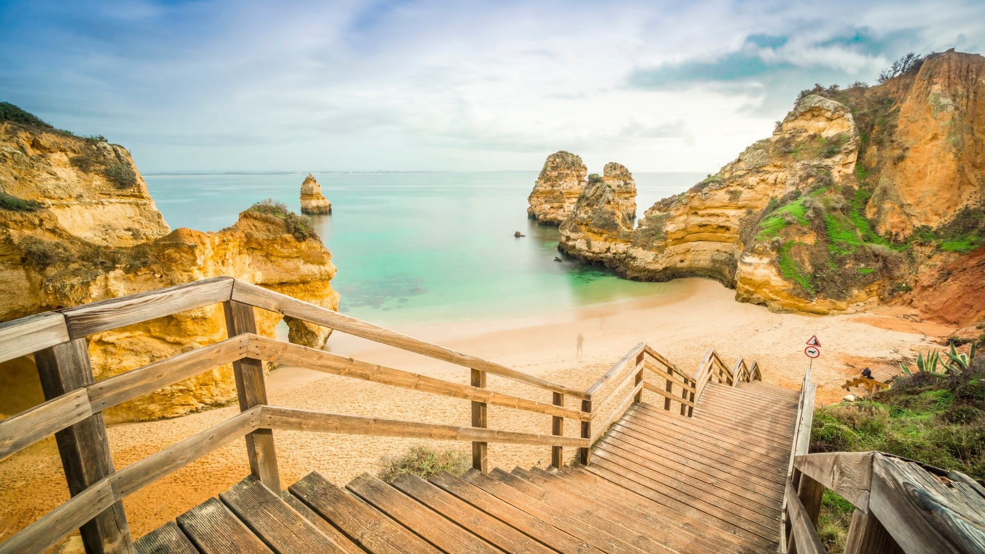 Beautiful Camilo Beach with wooden walkway descending to the sandy beach in Lagos, Algarve, Portugal