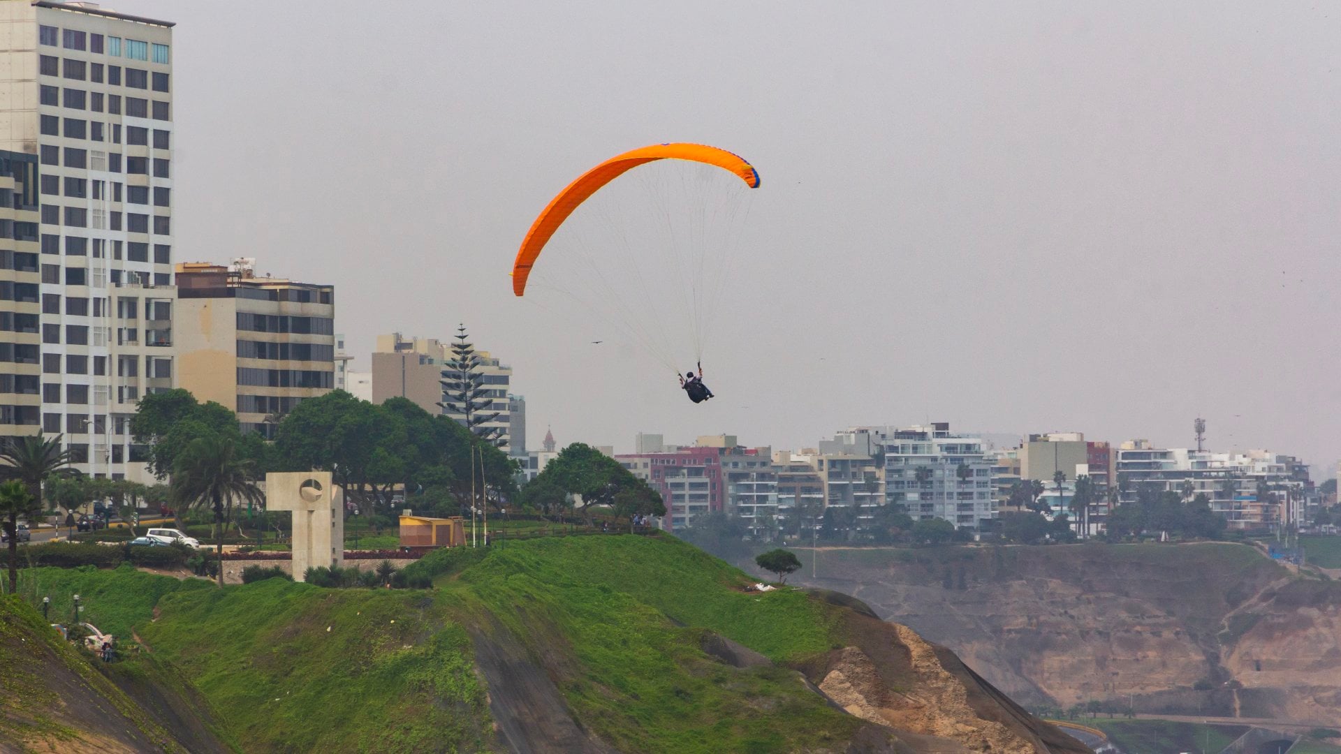 Paragliders sail over the Pacific Ocean off the cliffs of Miraflores.