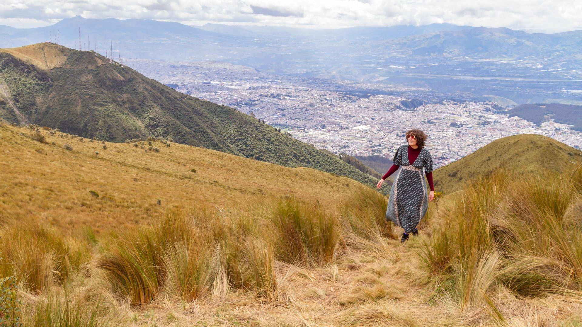 Portrait of young teenager solo traveler female walking to the top of the Pichincha's volcano mountain. On Back, the ecuatorian capital: Quito. Carefree backpacker fashion woman, in Quito, Pichincha, Ecuador