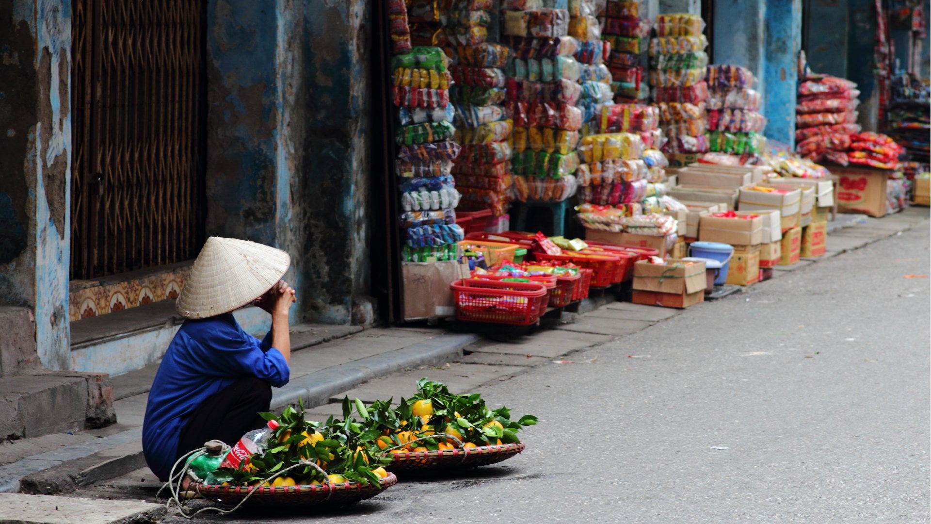 Hanoi, Vietnam Street vendor in Vietnam selling fruit at a corner in Hanoi, Vietnam