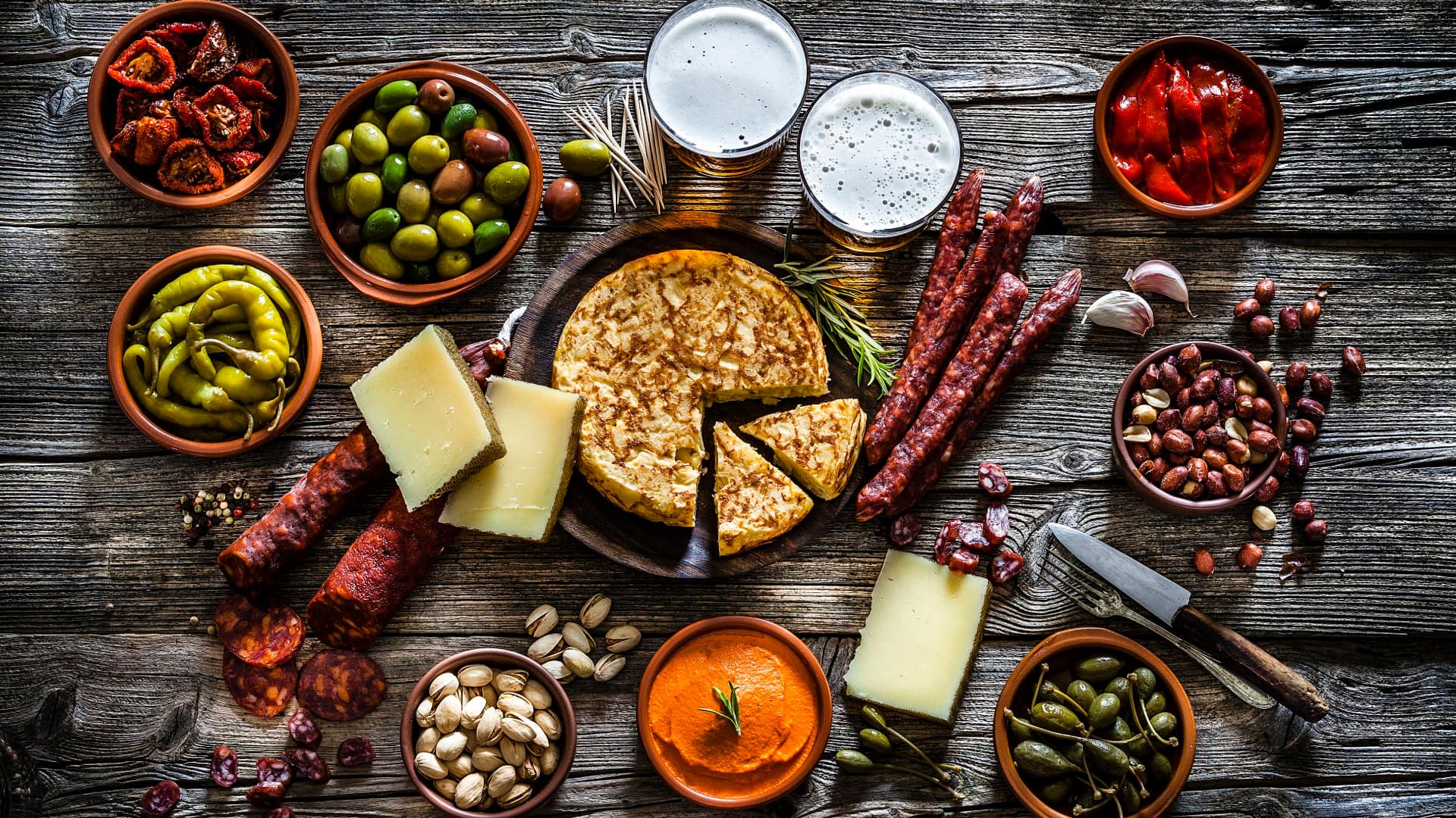 Tapas and beer: typical spanish food shot from above on rustic wooden table 