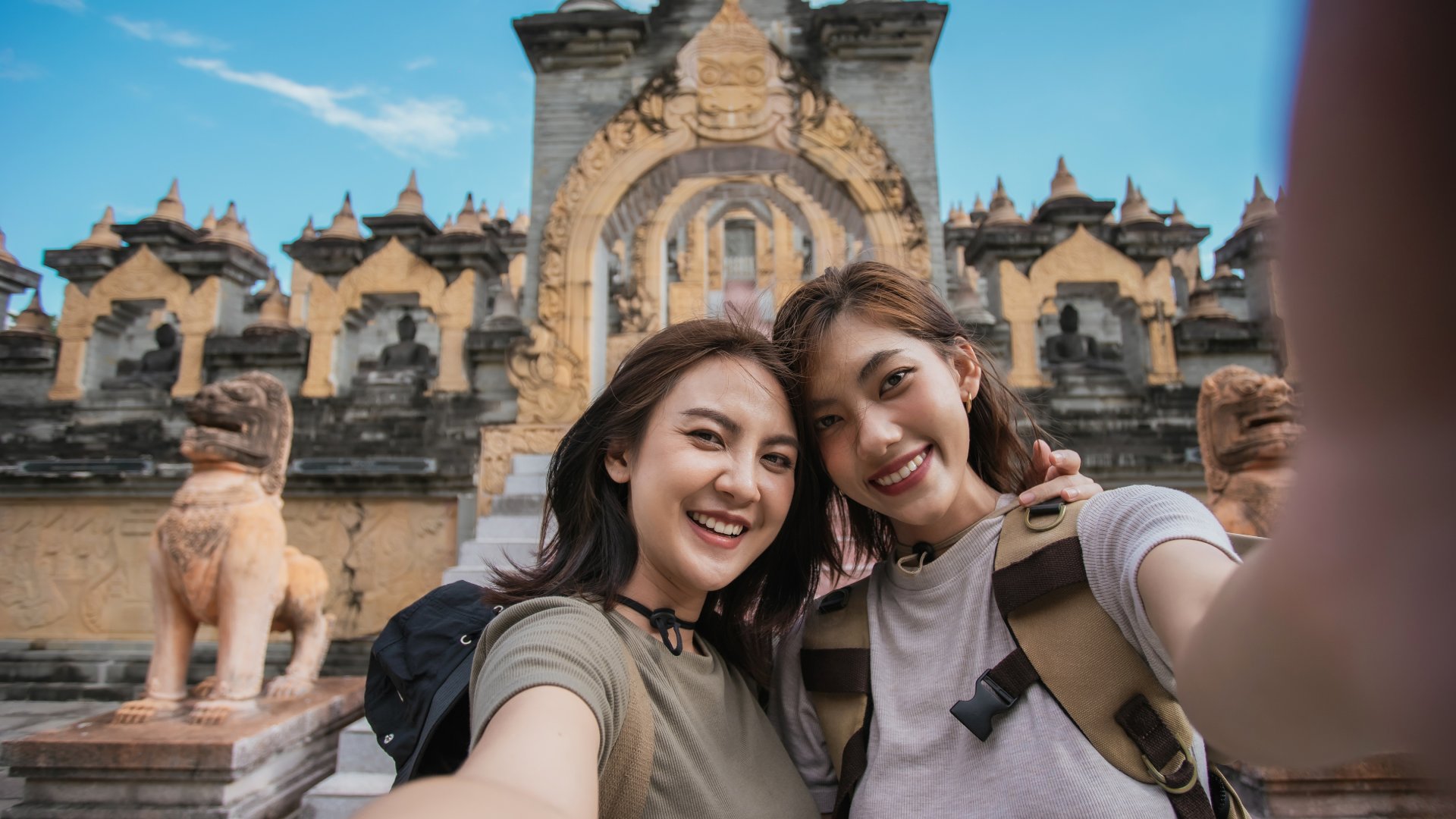 Two Asian woman traveler smile take a photo selfie together with pagoda of buddhist temple in background. Travel pagoda of buddhist in Asia.
