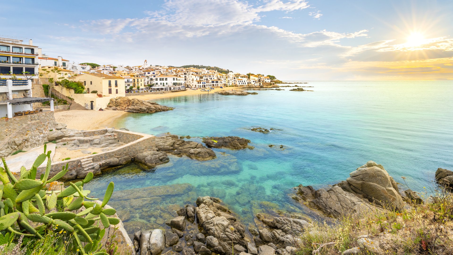 View of the sandy beach, rocky coastline and whitewashed town