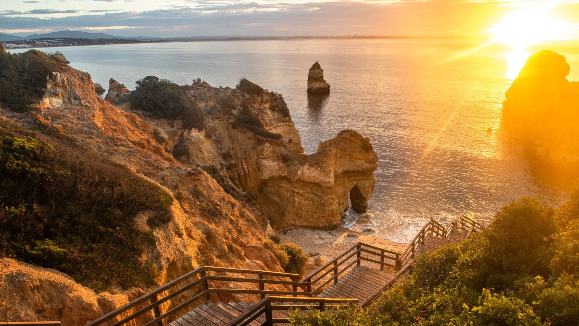 Algarve, Portugal Wooden footbridge to beautiful beach Praia do Camilo near Lagos in Portugal at sunrise