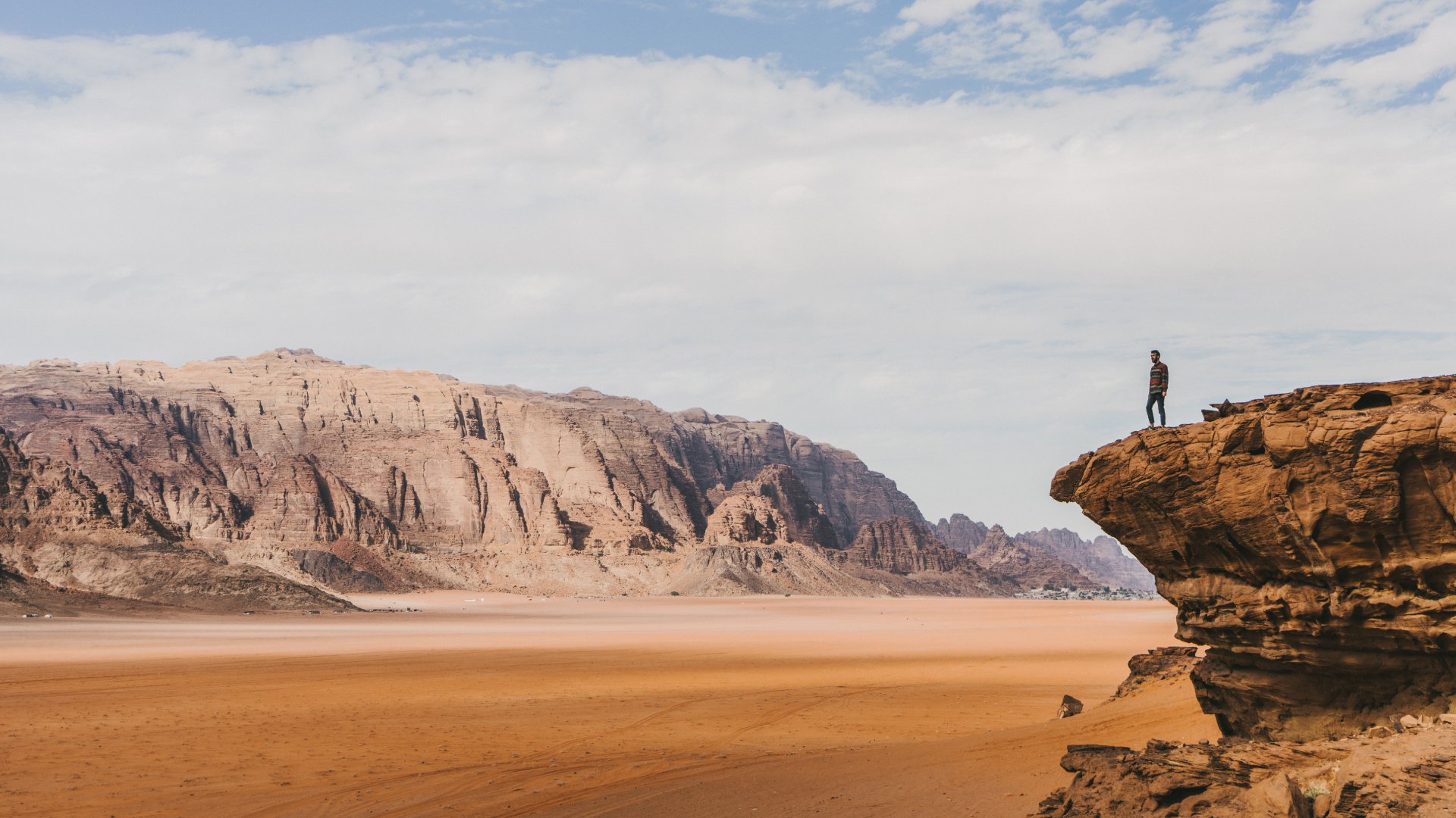 Young Caucasian woman looking at Wadi Rum desert from above at sunset