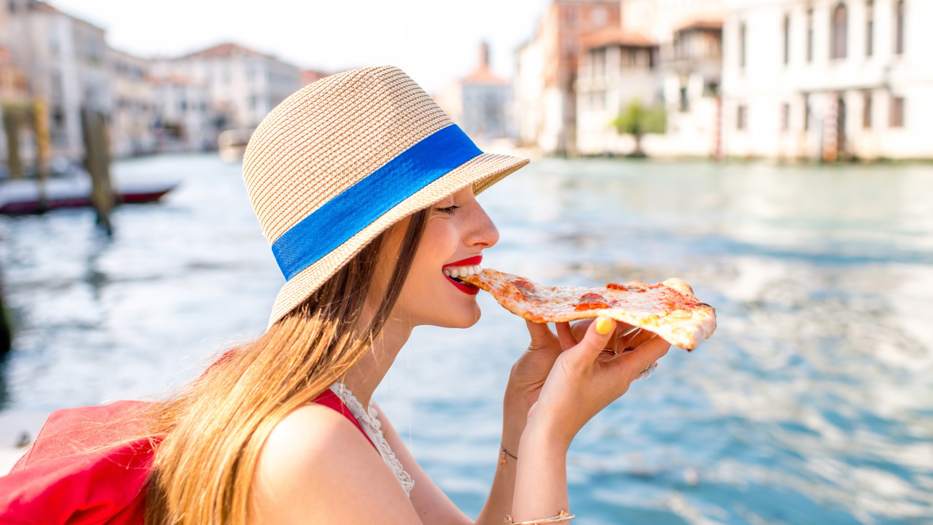 Young Woman eating traditional italian pizza slice, Venice, Italy