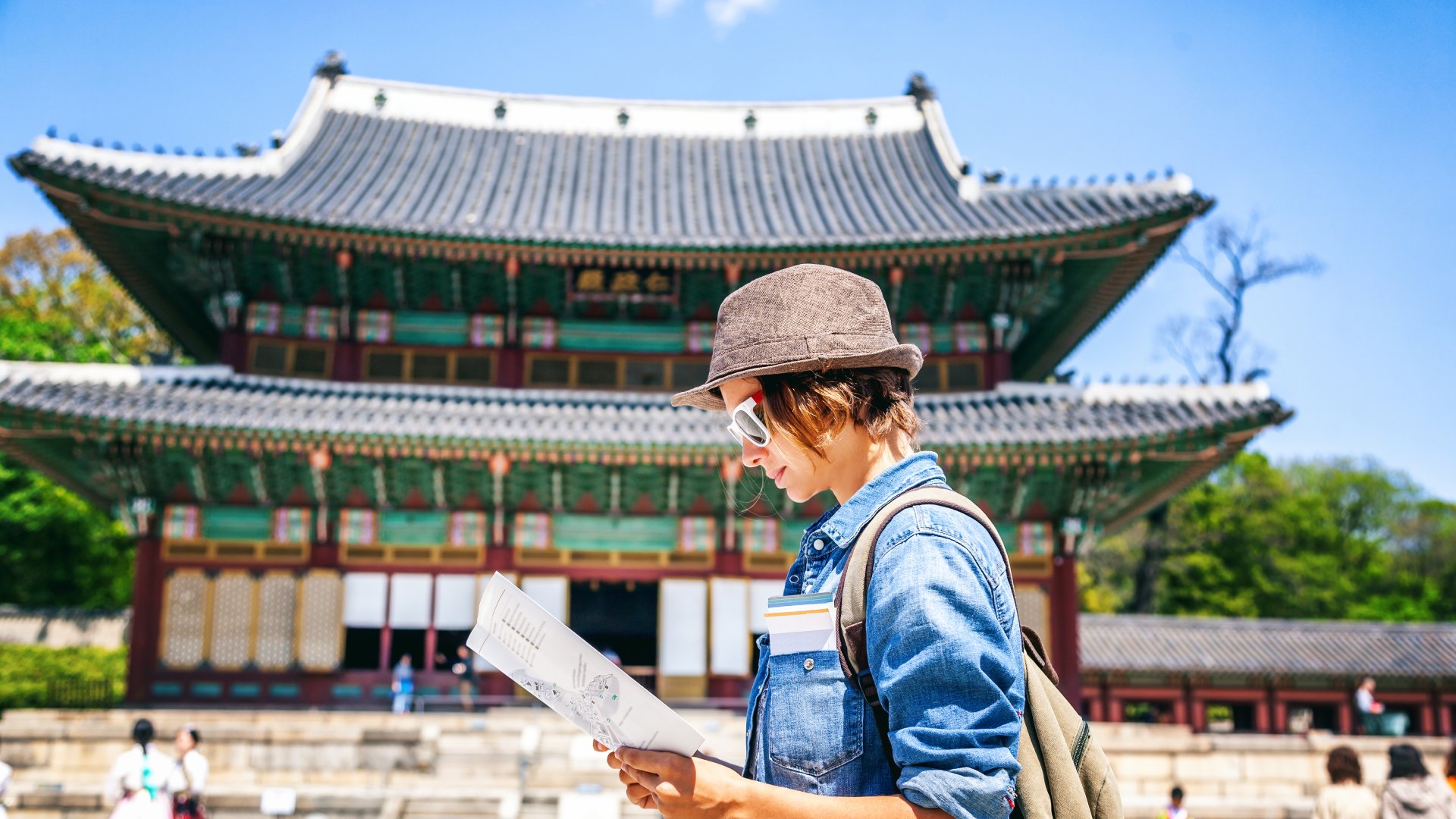 Young woman tourist with map in hand with Asian architecture, Seoul, South Korea