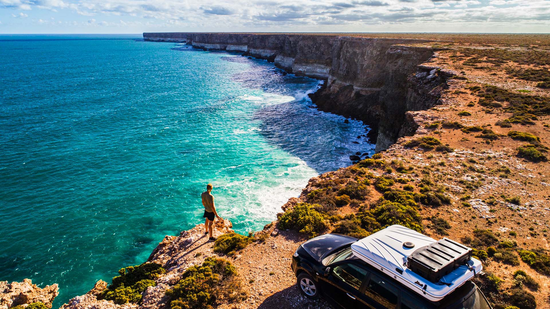 Great Australian Bight, Australia A man standing beside his car on the coastline along the Great Australian Bight of Australia