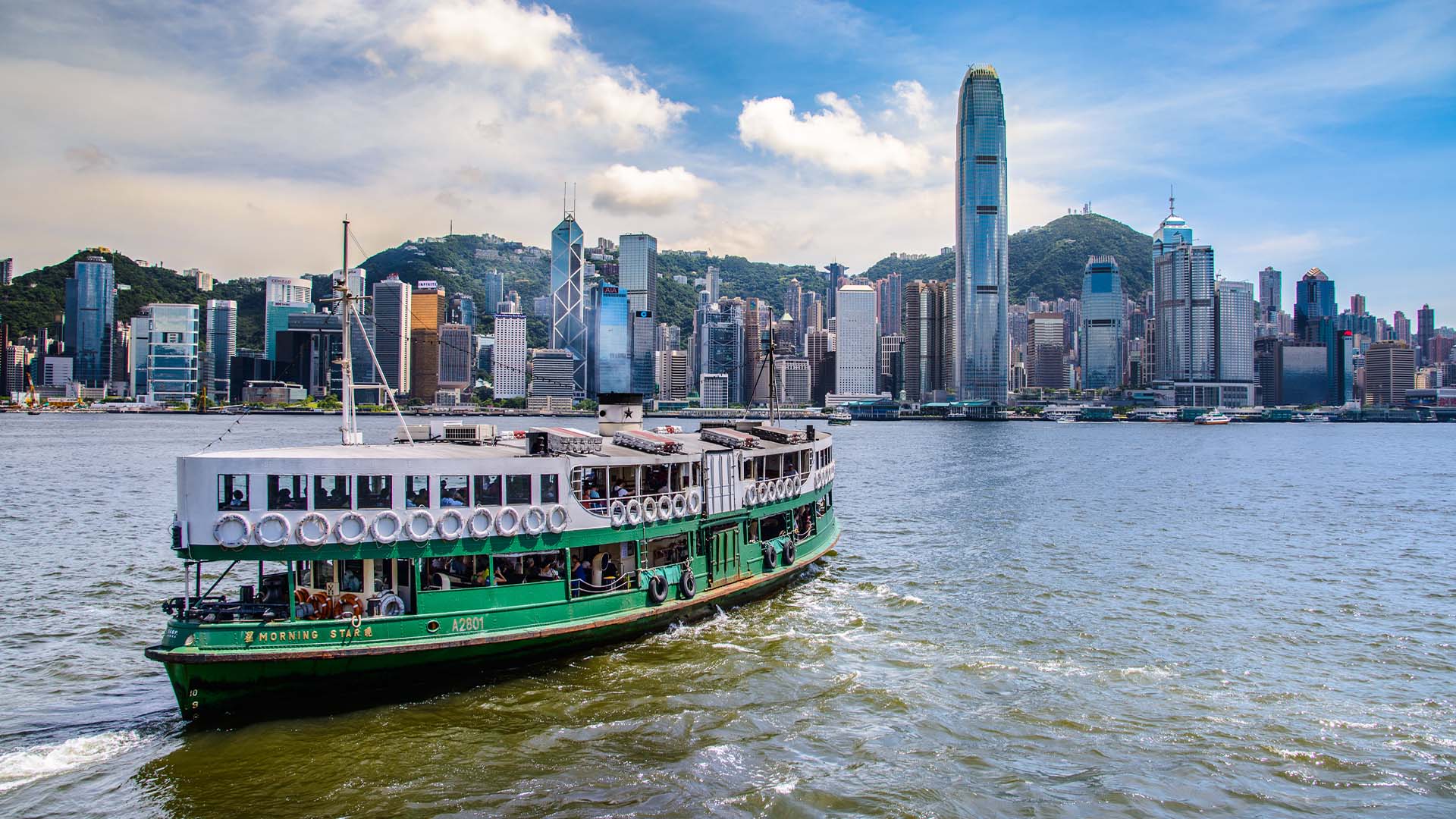 Star Ferry in Hong Kong crossing Victoria Harbour during the day.