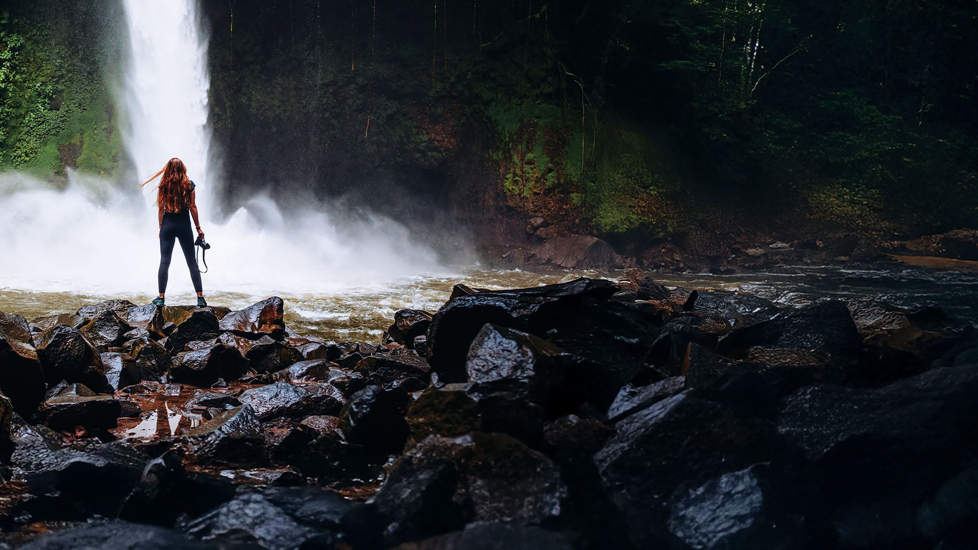 La Fortuna, Costa Rica A woman with a camera at La Fortuna waterfall in Costa Rica