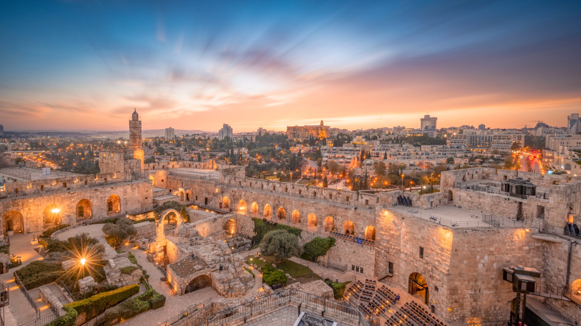 ruins and gardens set against a backdrop of a desert city
